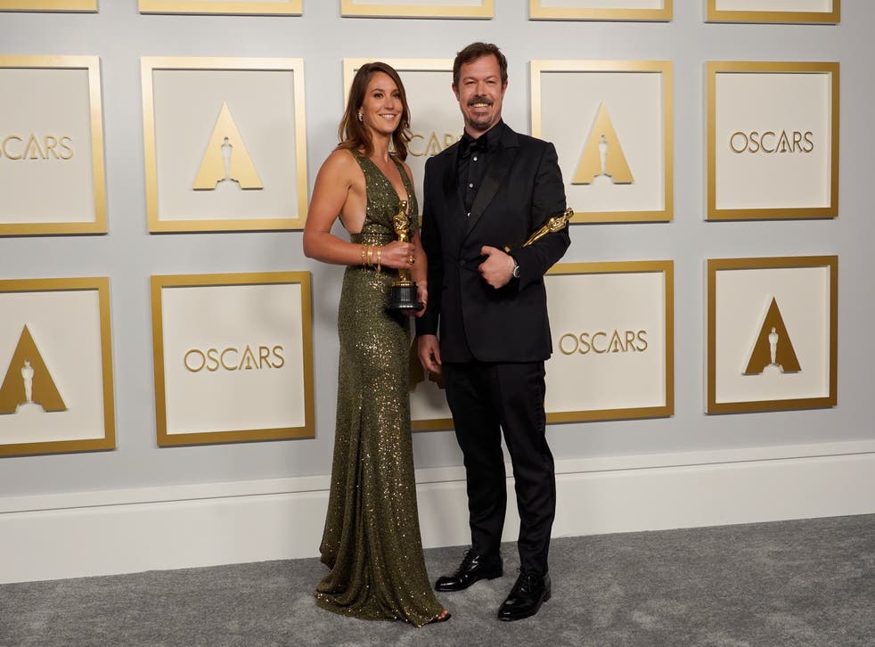 <p>Pippa Ehrlich and James Reed with the award for best documentary feature for 'My Octopus Teacher' </p>