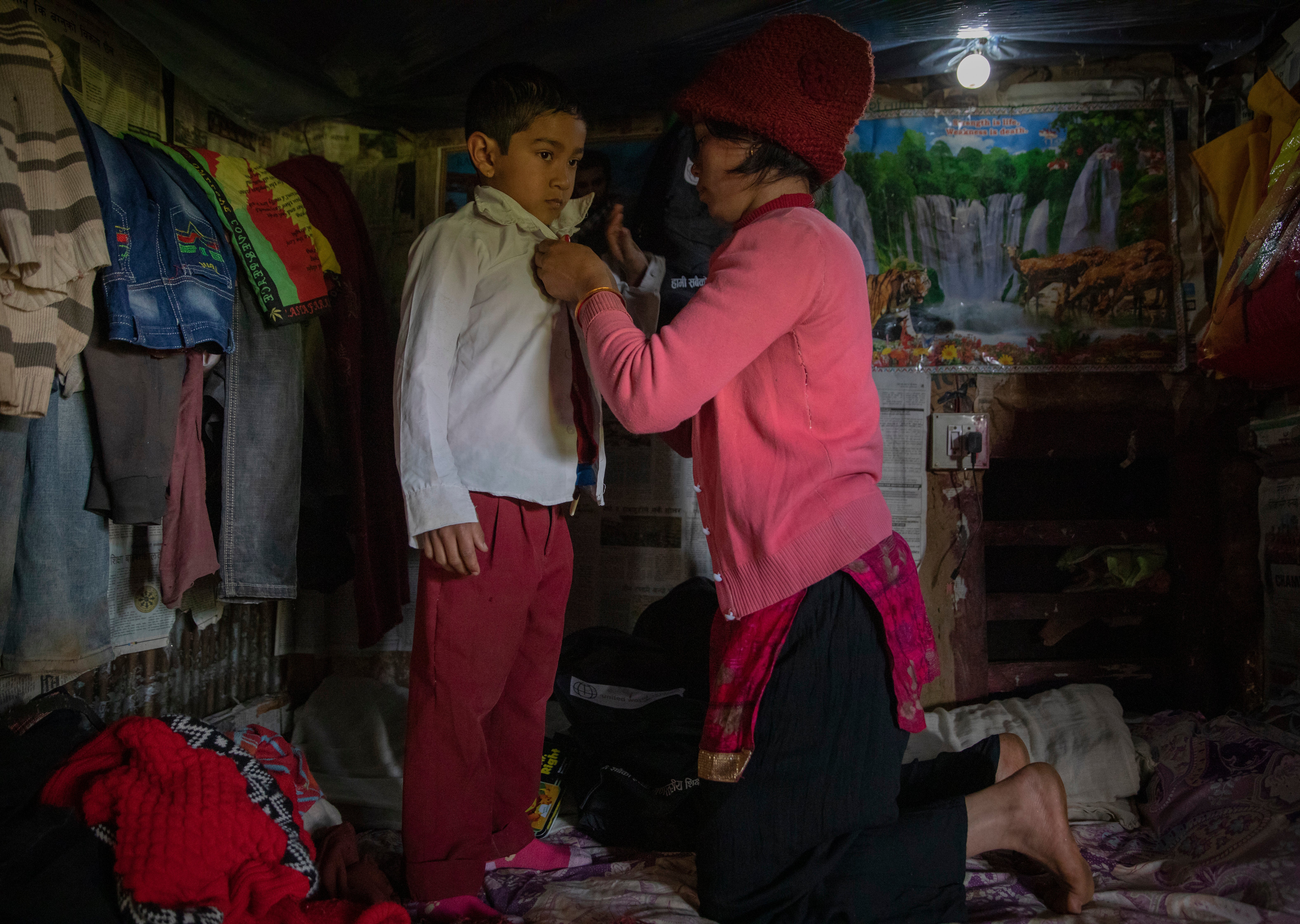 Anjana Poudel, 25, helps her son Amir, 6, get ready for school. She says: “ We believe through education he can have a future away from simply living without dreams. We are investing in him in the hope that a life out of poverty can become real.”