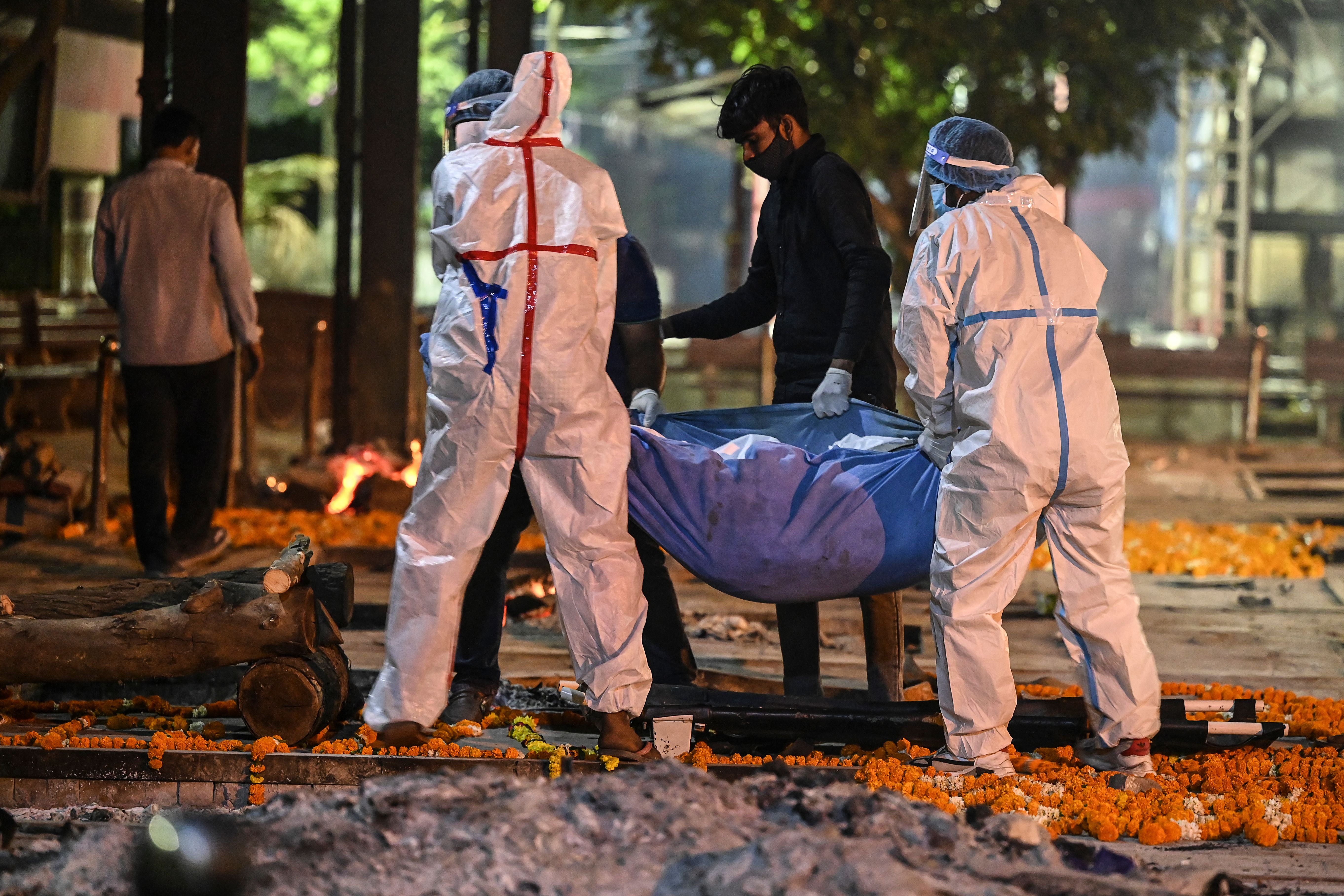 <p>Relatives and family members carry the dead body of a Covid-19 victim for a cremation  in New Delhi</p>
