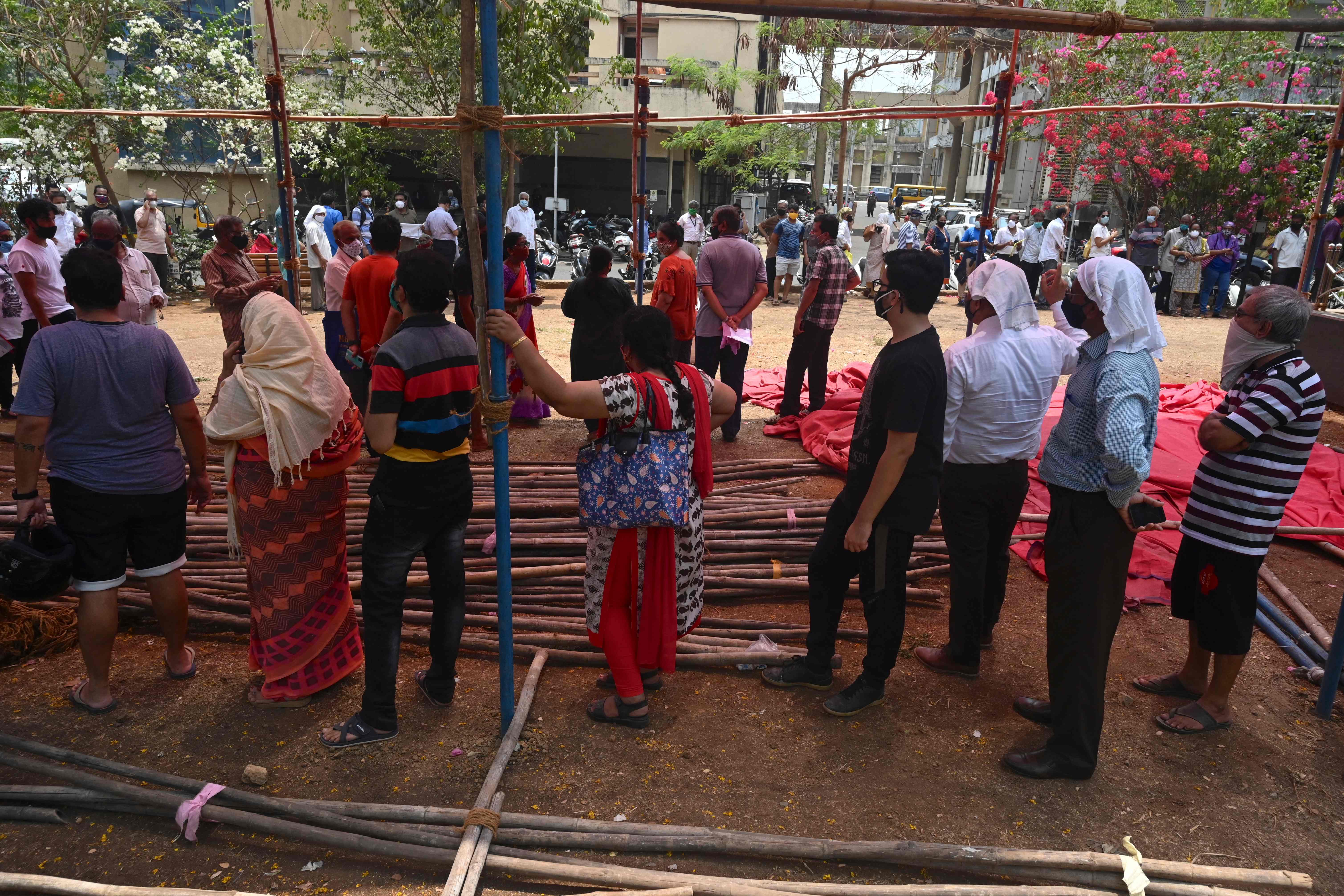 People stand in queues to get their Covid-19 coronavirus vaccine at a centre in Mumbai