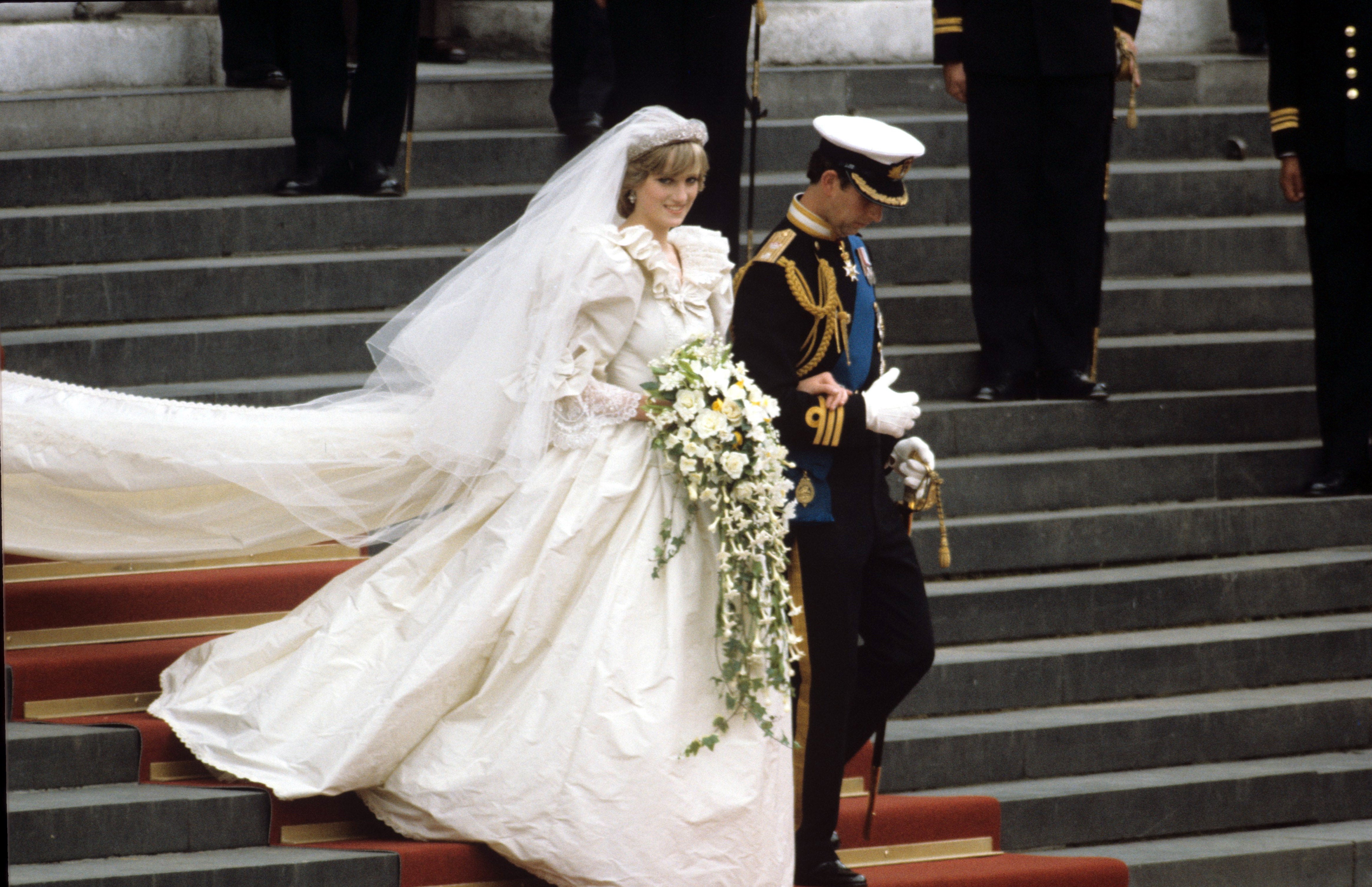 Princess Diana and Prince Charles on their wedding day in July 1981. The gown was designed by David and Elizabeth Emanuel and has a fitted bodice covered in panels of antique Carrickmacross lace. It originally belonging to Prince Charles’ great grandmother Queen Mary. It also features a 25-foot long train - the longest in royal history. The actor Emma Corrin wore a replica of the gown for the fourth series of The Crown , in which she portrayed Diana.