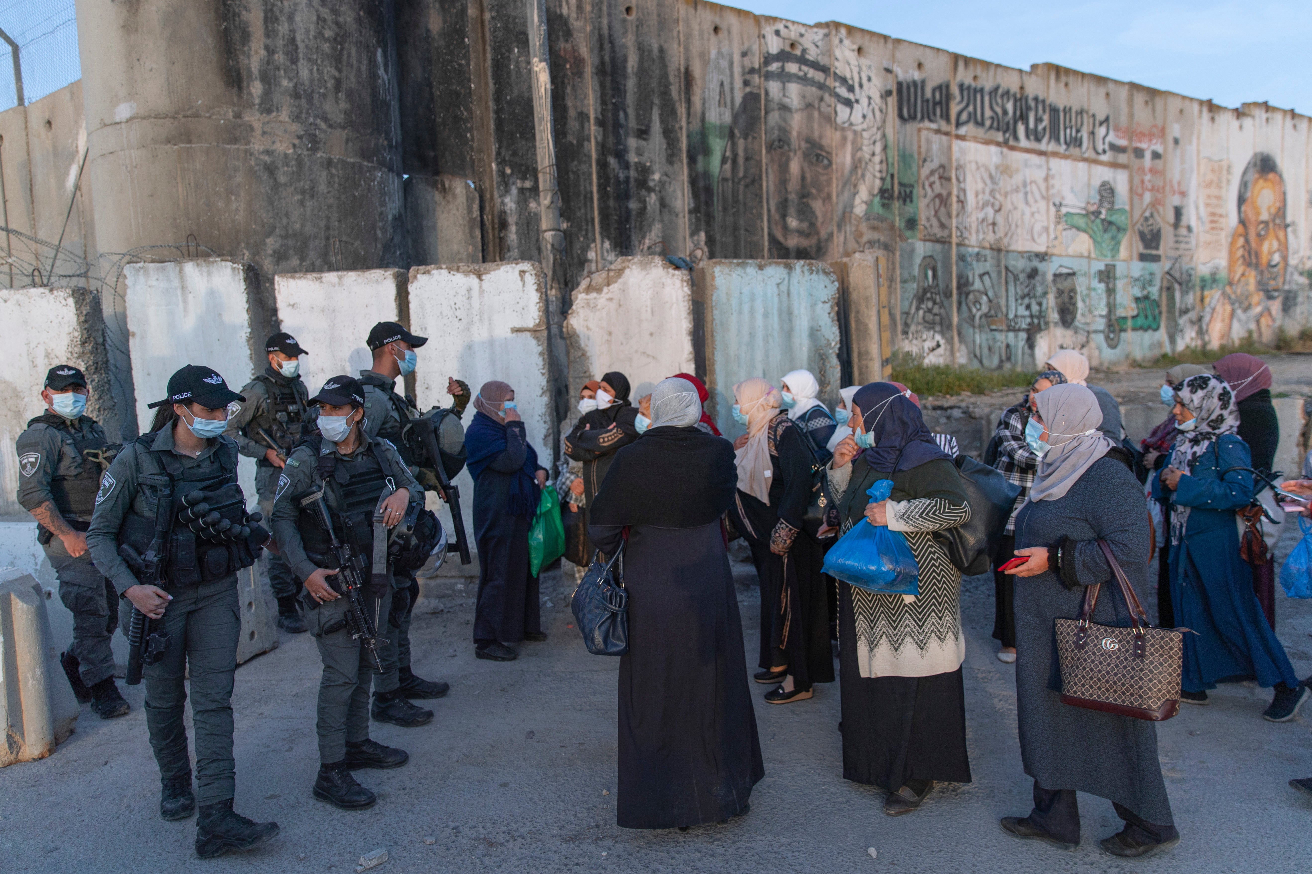 Palestinians wait to cross the Qalandia checkpoint between the West Bank city of Ramallah and Jerusalem