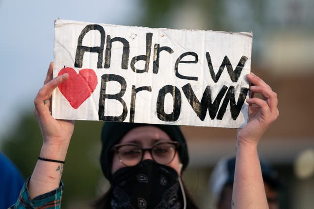 <p>ELIZABETH CITY, NC - APRIL 22: A demonstrator holds a sign for Andrew Brown Jr. during a protest march on April 22, 2021 in Elizabeth City, North Carolina. The protest was sparked by the police killing of Brown on April 21.</p>