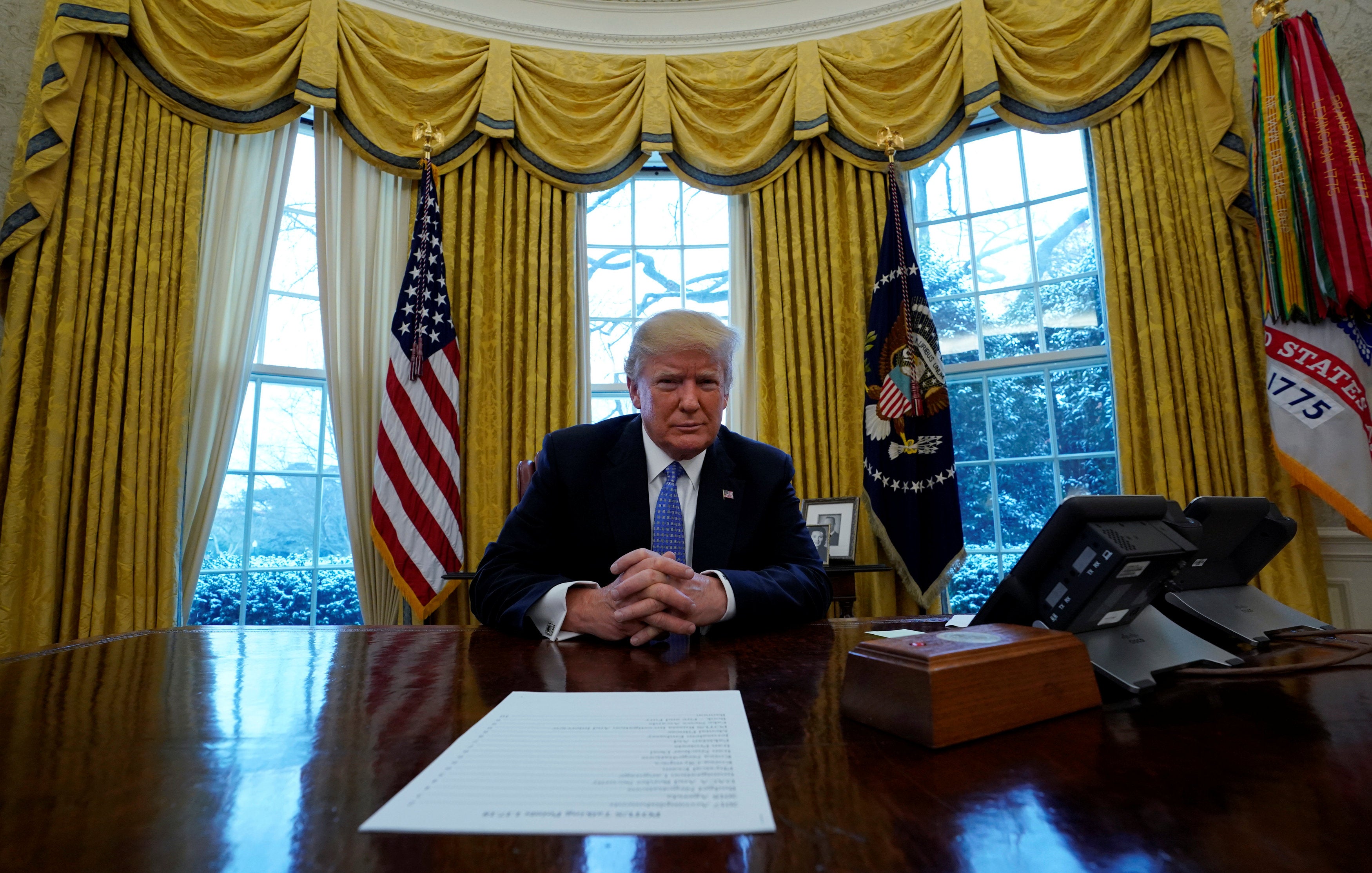 Donald Trump sits at the Resolute Desk
