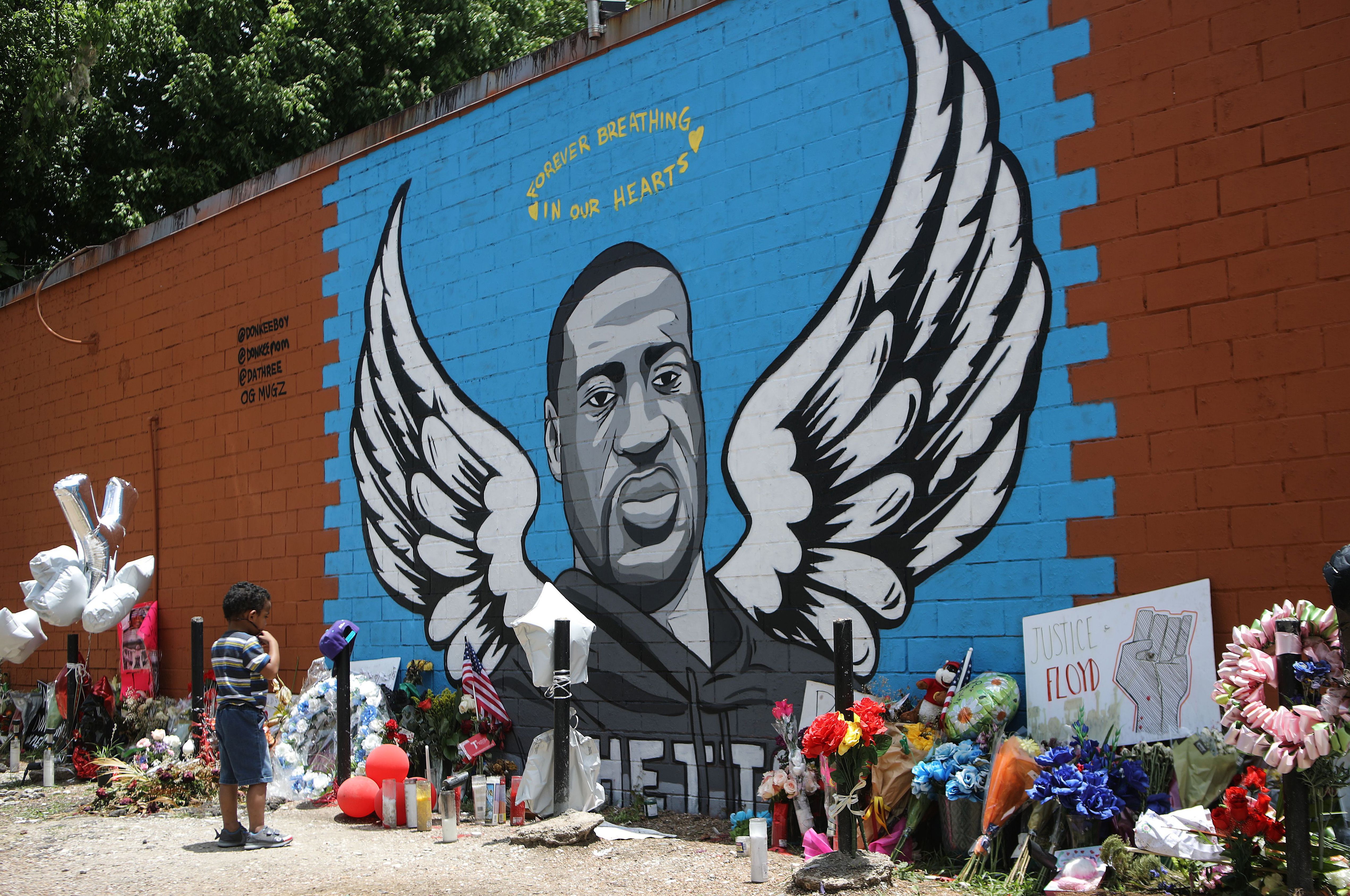 A child views a mural dedicated to George Floyd, across the street from the Cuney Homes housing project in Houston's Third Ward, where Floyd grew up and later mentored young men, on June 10, 2020 in Houston, Texas.