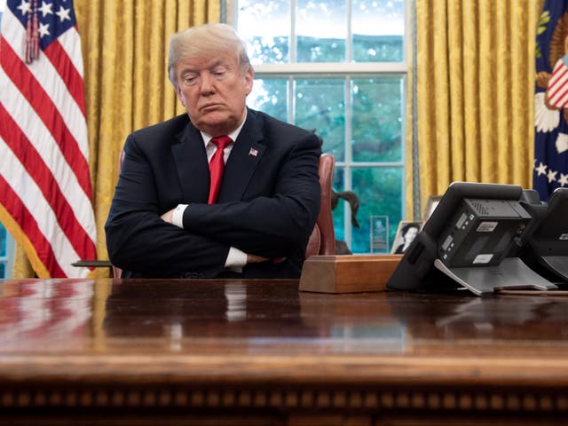 US President Donald Trump sits at the Resolute Desk during a briefing on Hurricane Michael in the Oval Office of the White House in Washington, DC, on 10 October 2018