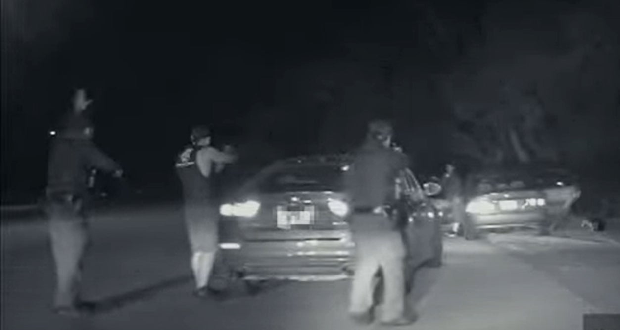 <p>A still from an Austin patrol car dash cam shows Texas officers holding Alex Gonzales at gun point in January after an alleged road rage incident. Mr Gonzales was shot ten times and died at the scene. </p>