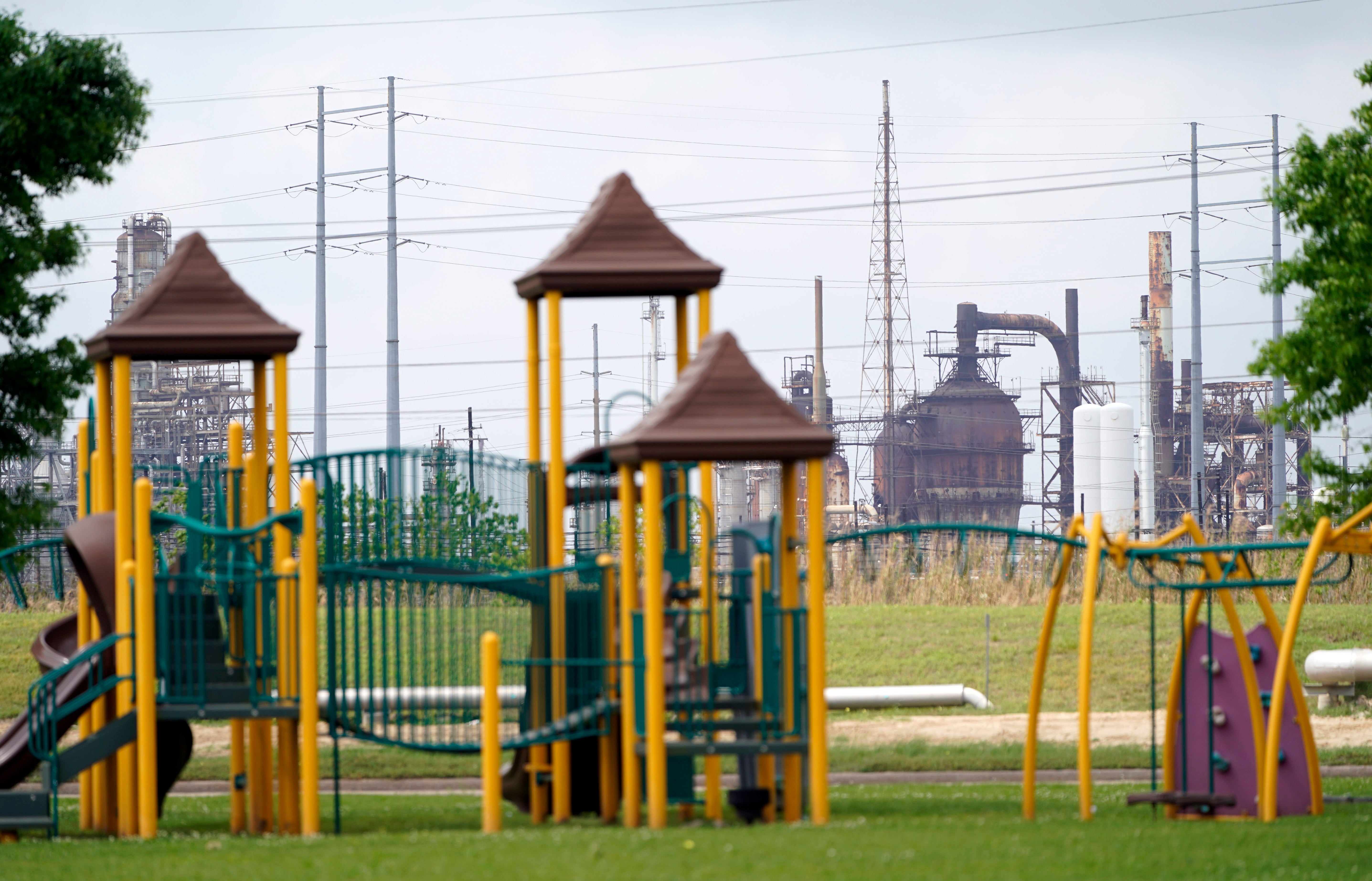 In this Monday, March 23, 2020 file photo, a playground outside the Prince Hall Village Apartments sits empty near one of the petrochemical facilities in Port Arthur, Texas. According to a study published Wednesday, April 28, 2021 in the journal Science Advances, across America, people of color are disproportionately exposed to air pollution from industry, vehicles, construction and many other sources. (AP Photo/David J. Phillip)