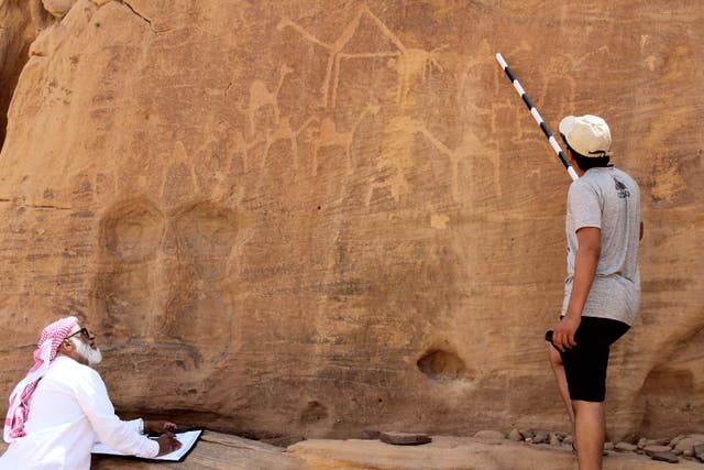 <p>An AlUla resident and his son, trained through the Royal Commission for AlUla, work to record rock art from all eras in the Rukab Mountains.</p>