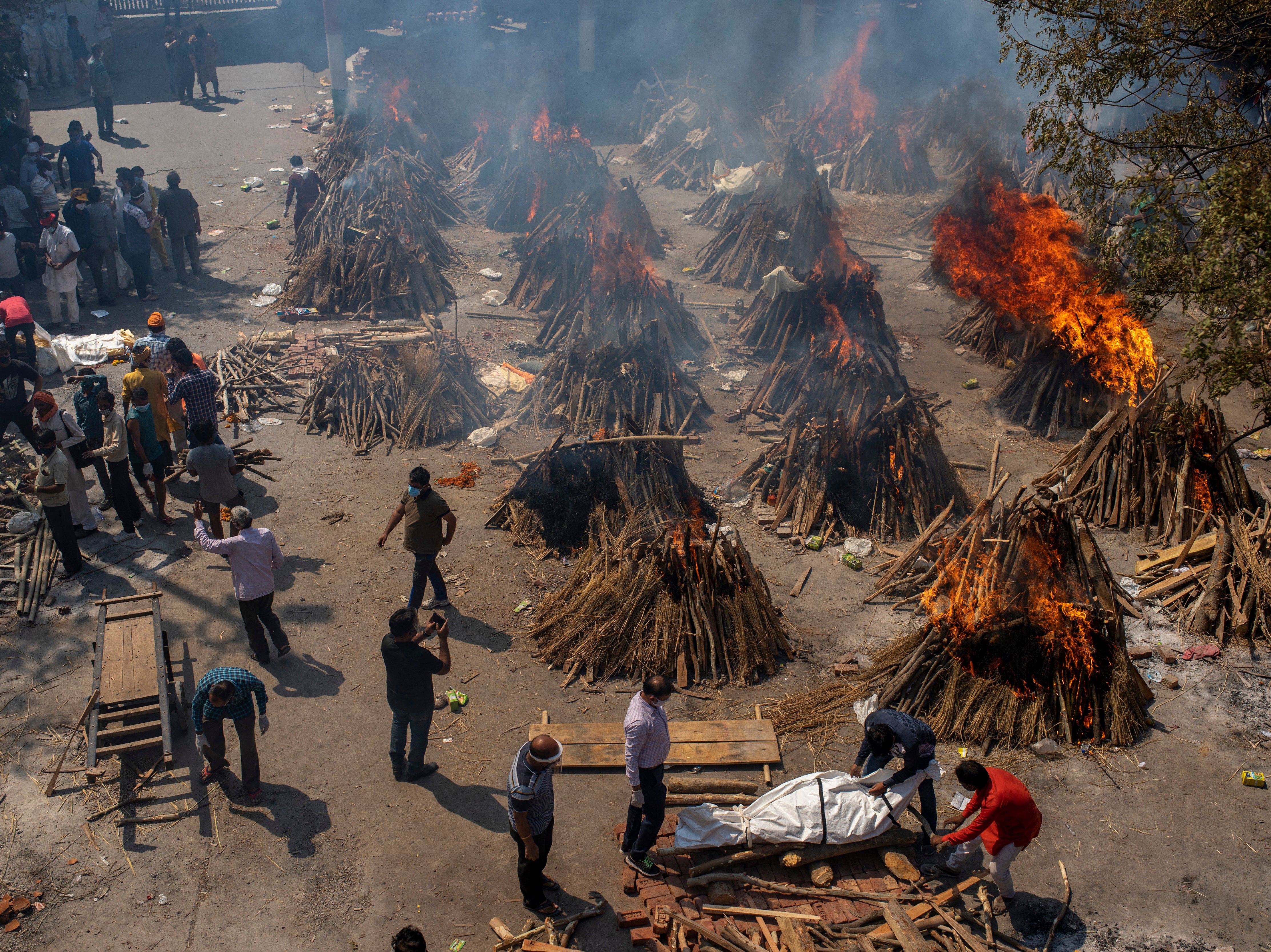 File: In this 24 April photo, multiple funeral pyres of victims of Covid-19 burn at a ground that has been converted into a crematorium in Delhi