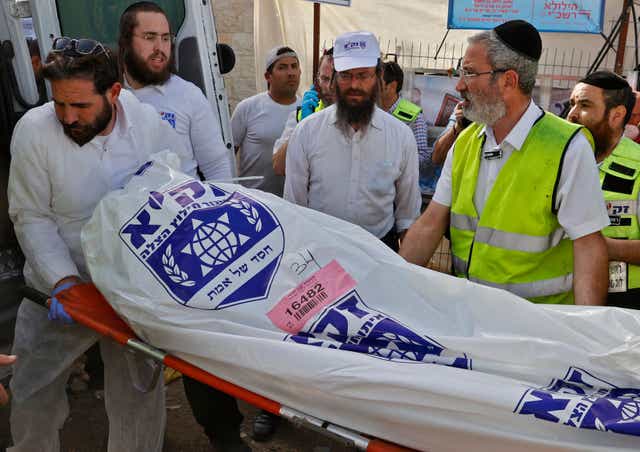 A rescue team carries a body bag into an ambulance on 30 April, 2021, after a fatal stampede near the town of Meron, Israel. 