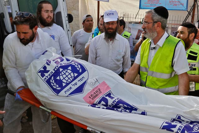 A rescue team carries a body bag into an ambulance on 30 April, 2021, after a fatal stampede near the town of Meron, Israel. 