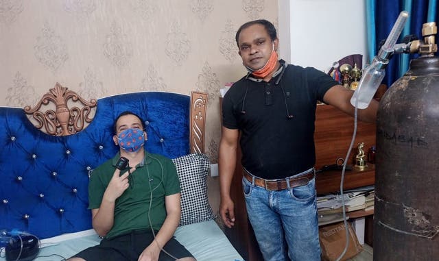 <p>Devendra Kumar Rai (black t-shirt) brought an oxygen cylinder from over 1,400 kilometres away for his childhood friend Rajan Kumar Singh (green t-shirt) who is suffering from coronavirus infection      </p>