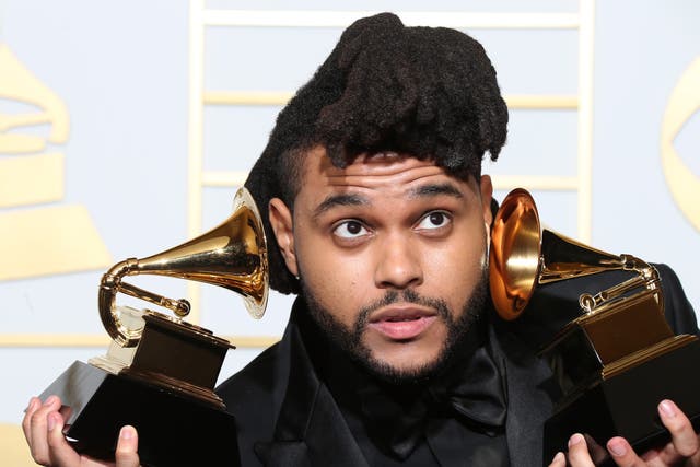 The Weeknd poses after winning the awards for Best R&B Performance and Best Urban Contemporary Album in 2016