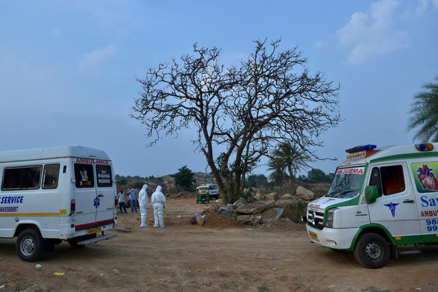 <p>Ambulances carry bodies of people who died of Covid-19, at an open-air crematorium in Karnataka on 1 May 2021</p>