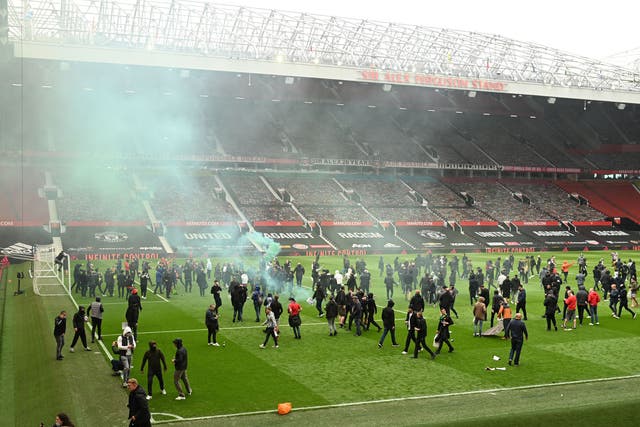 <p>Manchester United fans storm the pitch at Old Trafford</p>