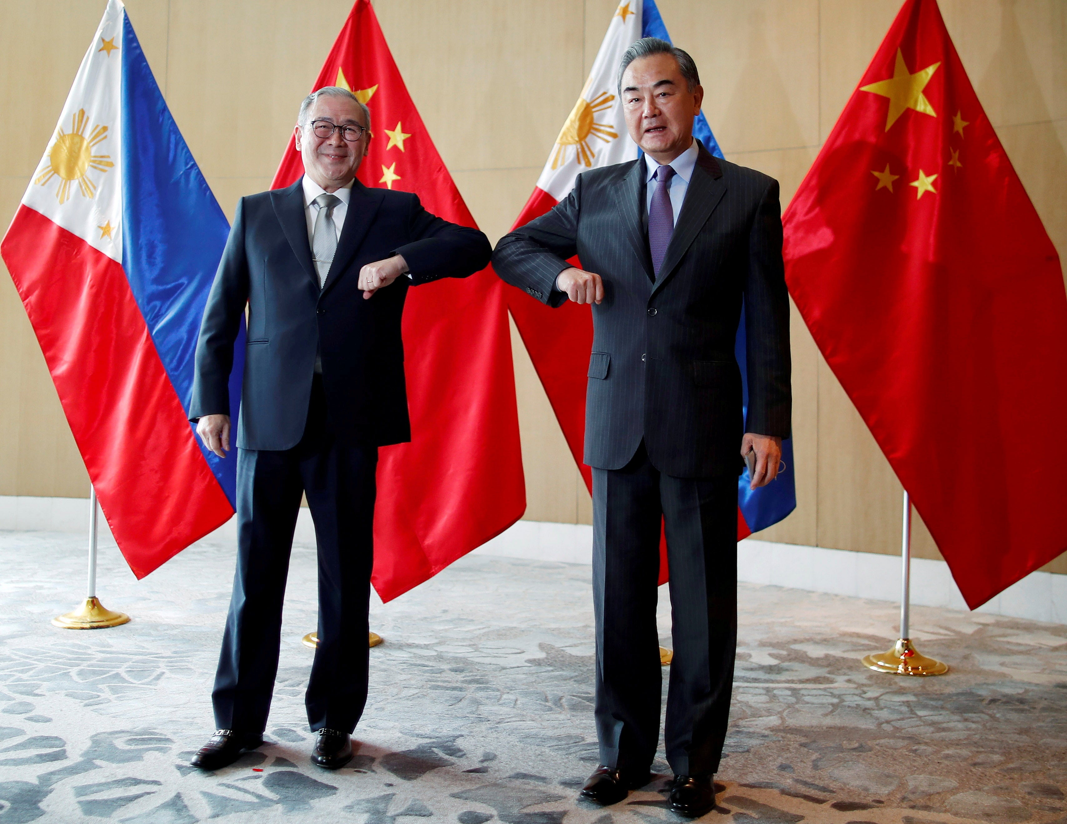 File image: China's Foreign Minister Wang Yi and Philippine's Foreign Affairs Secretary Teodoro Locsin Jr bump their elbows during a meeting in Manila, Philippines on 16 January, 2021