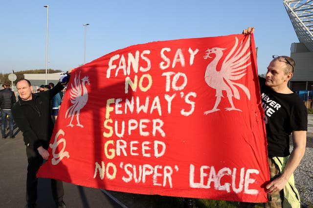 Fans hold up a protest banner against Liverpool’s owners
