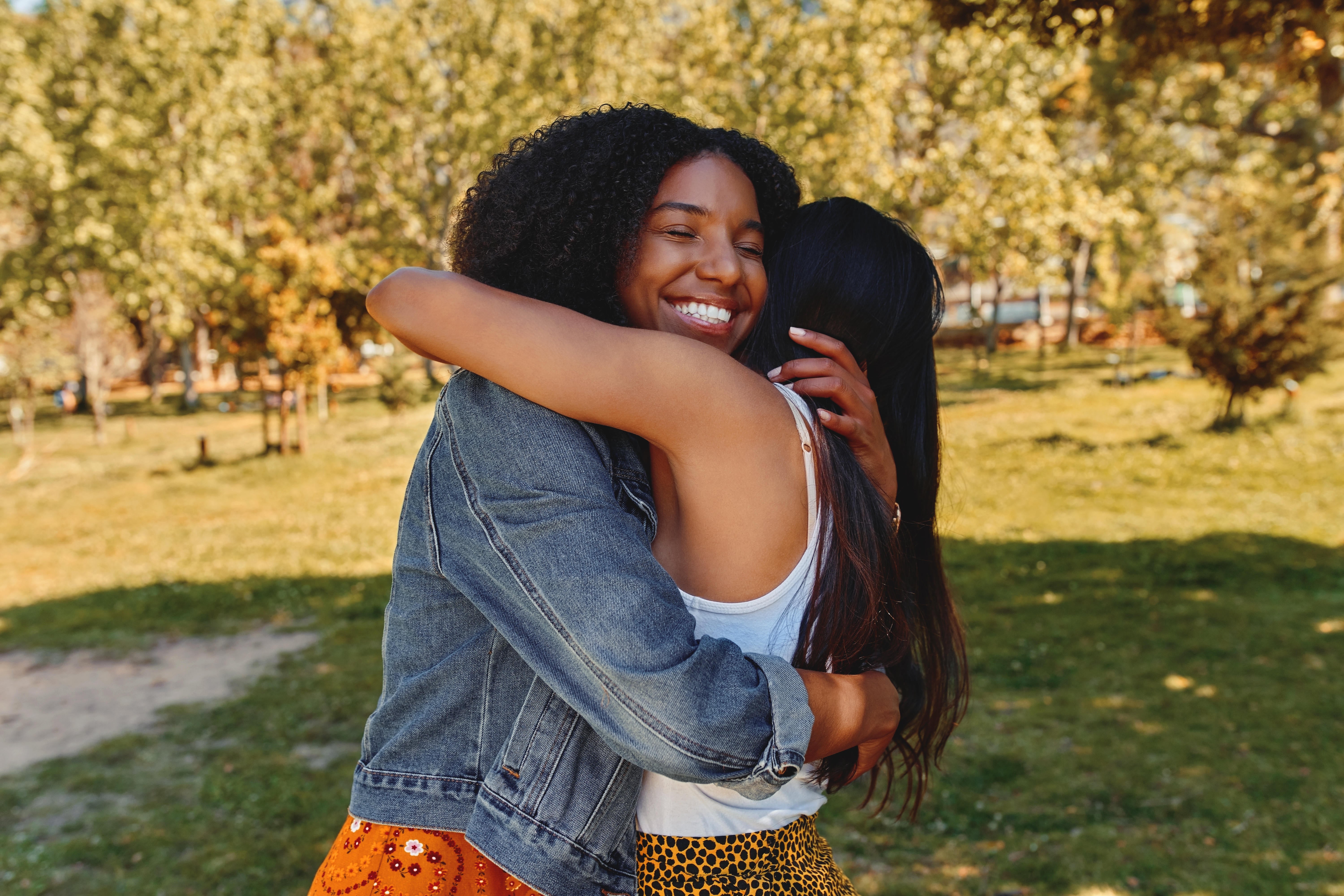 Two friends hugging in a park