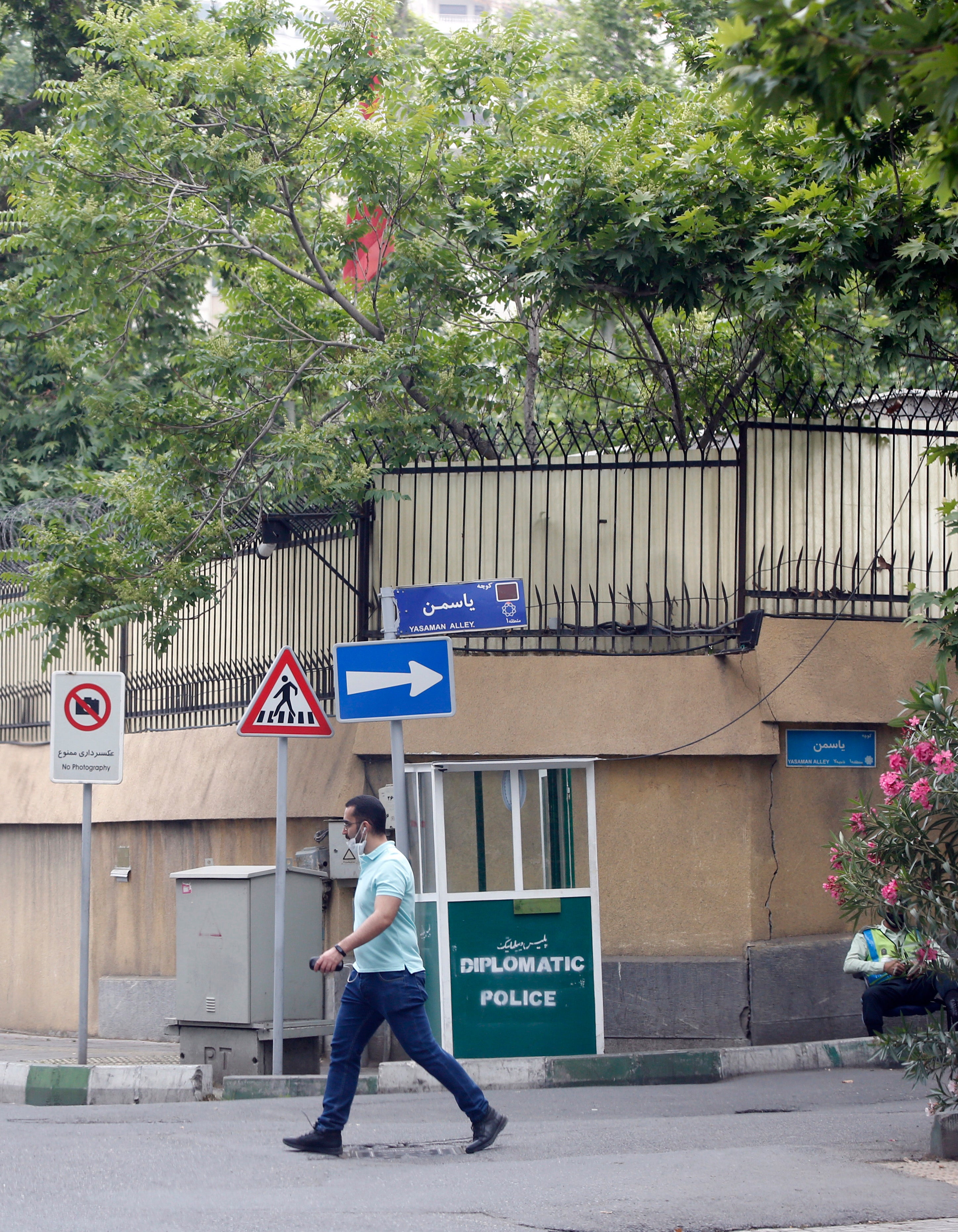 A man walks next to the entrance to the Swiss embassy in Tehran