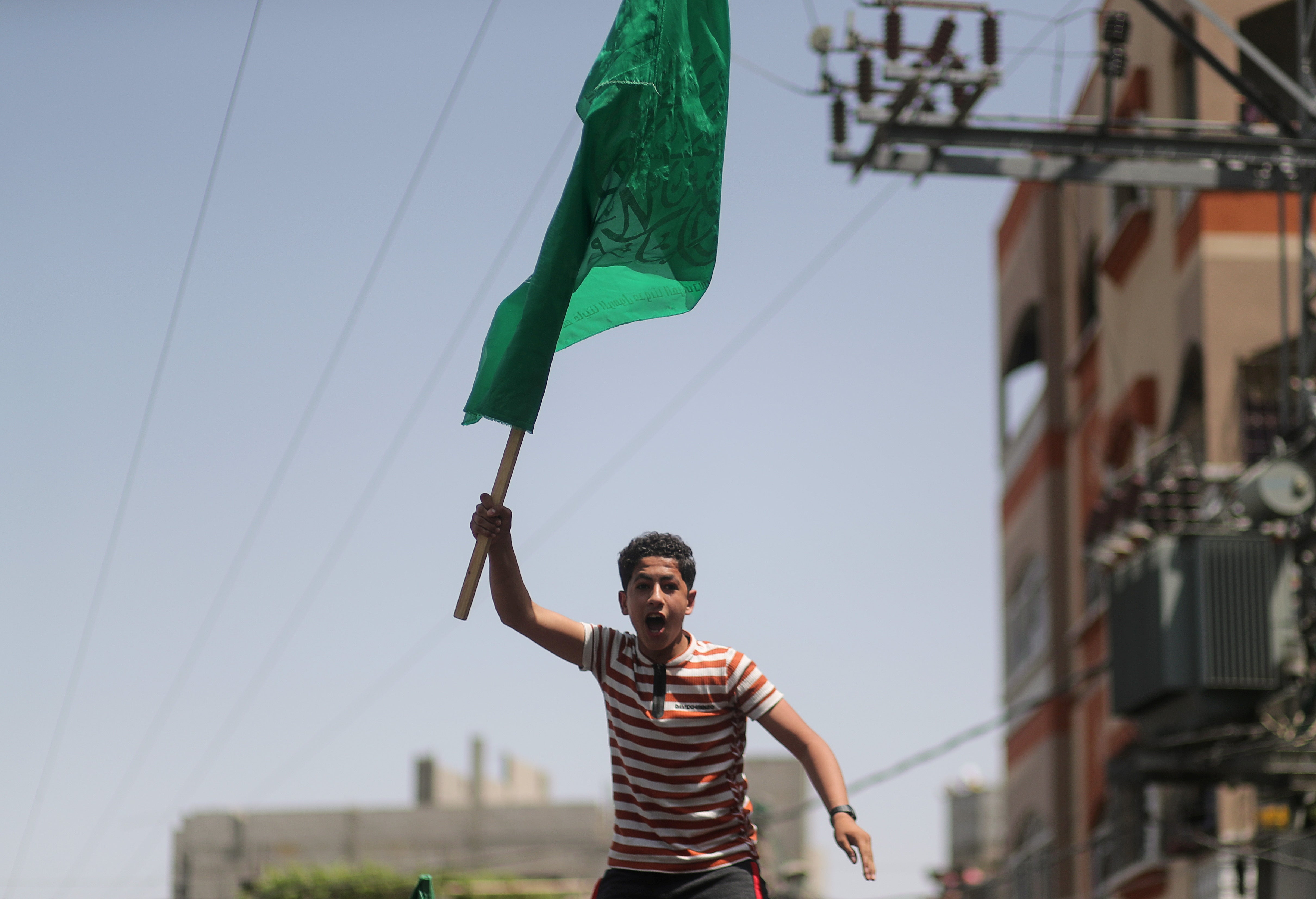 A Palestinian holds a Hamas flag during a protest following the announcement