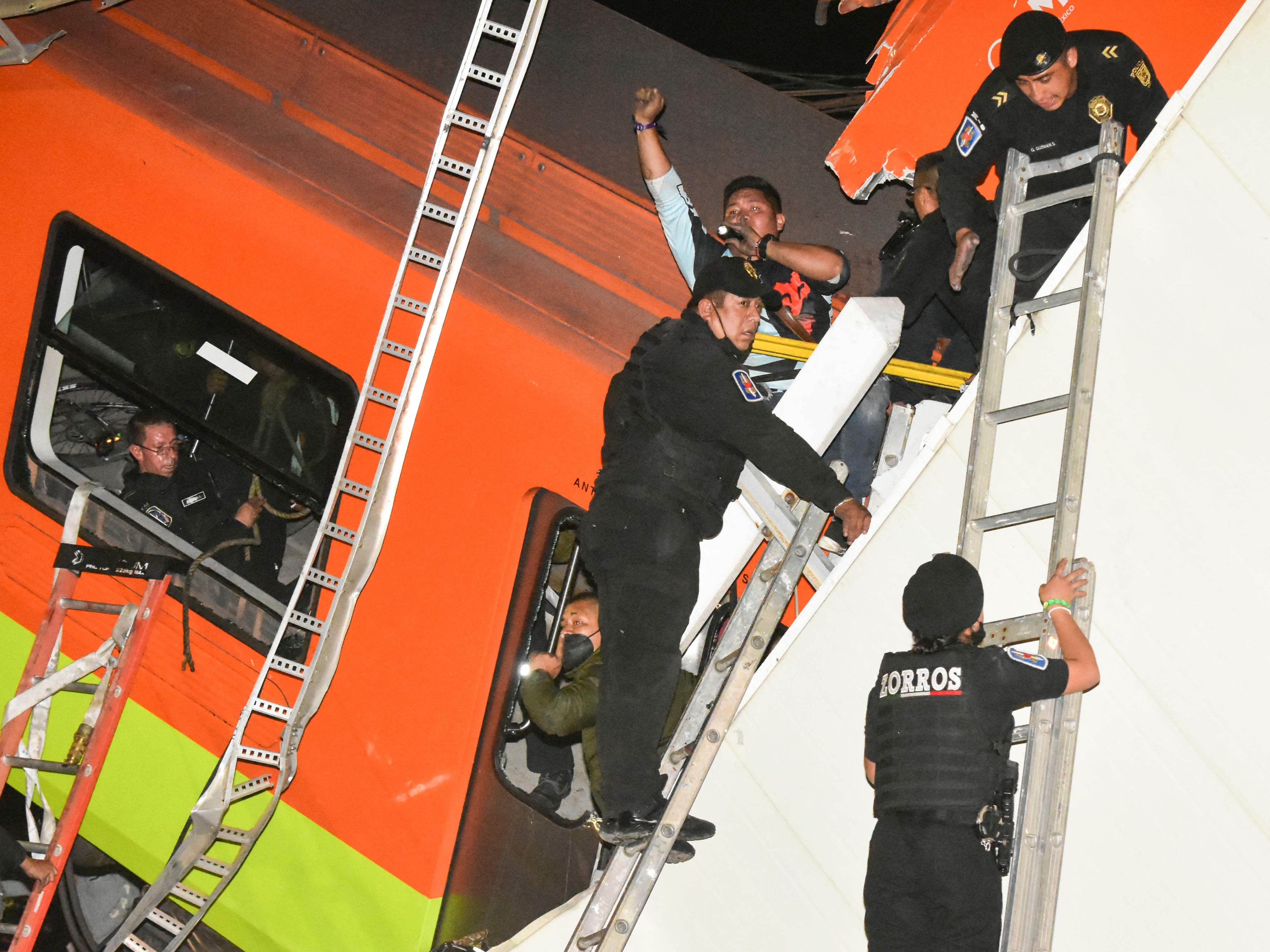 Rescue workers gather at the site of a metro train accident after an overpass for a metro partially collapsed in Mexico City on May 3, 2021.