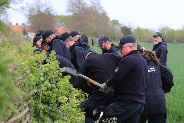 Police officers continue their search of fields close to the hamlet of Snowdown