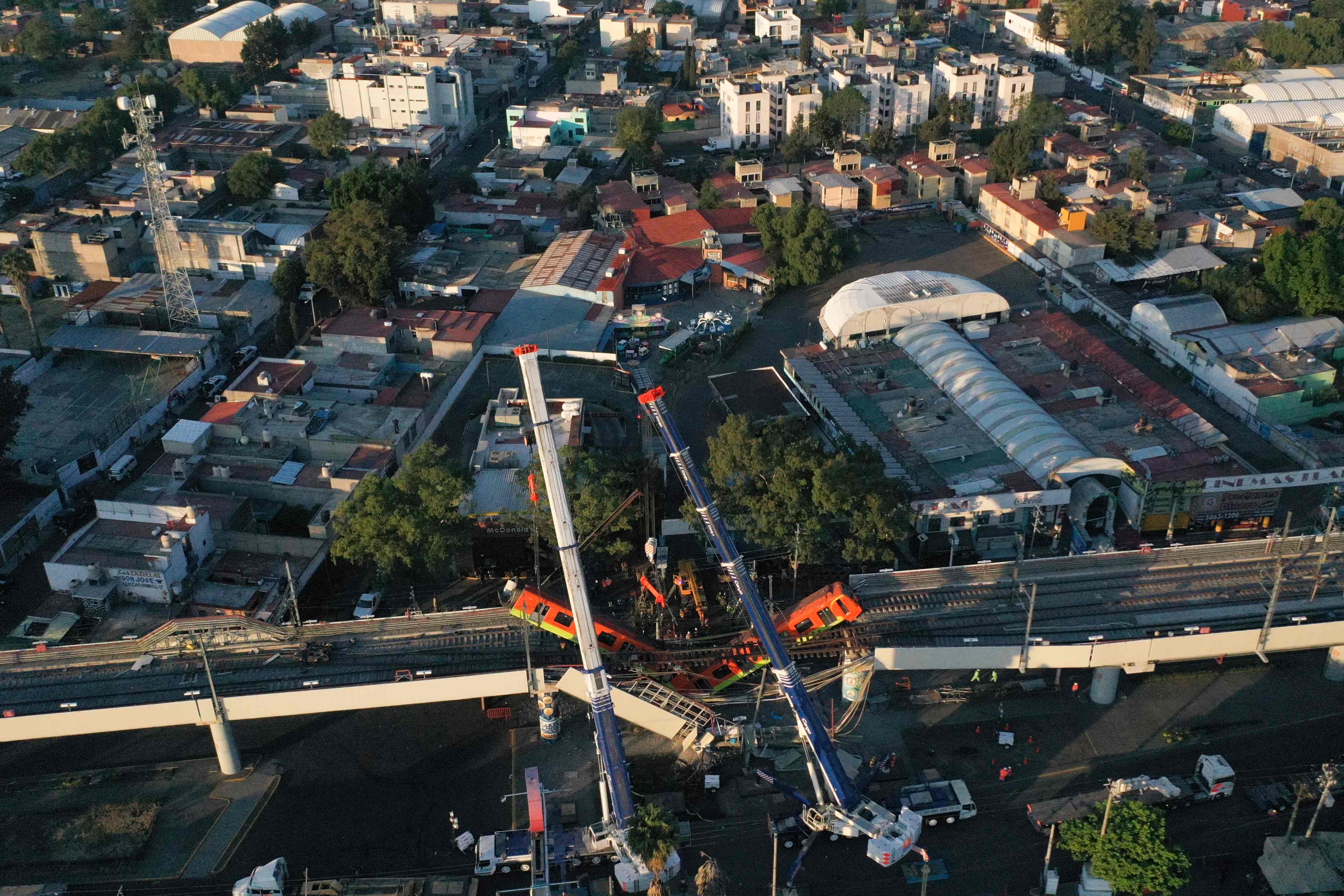 El sitio de un accidente de tren del metro después de que un paso elevado para un metro colapsara parcialmente en la Ciudad de México: una línea elevada del metro colapsó en la capital mexicana el lunes, dejando al menos 23 personas muertas y docenas de heridos cuando un tren se derrumbó, dijeron las autoridades.