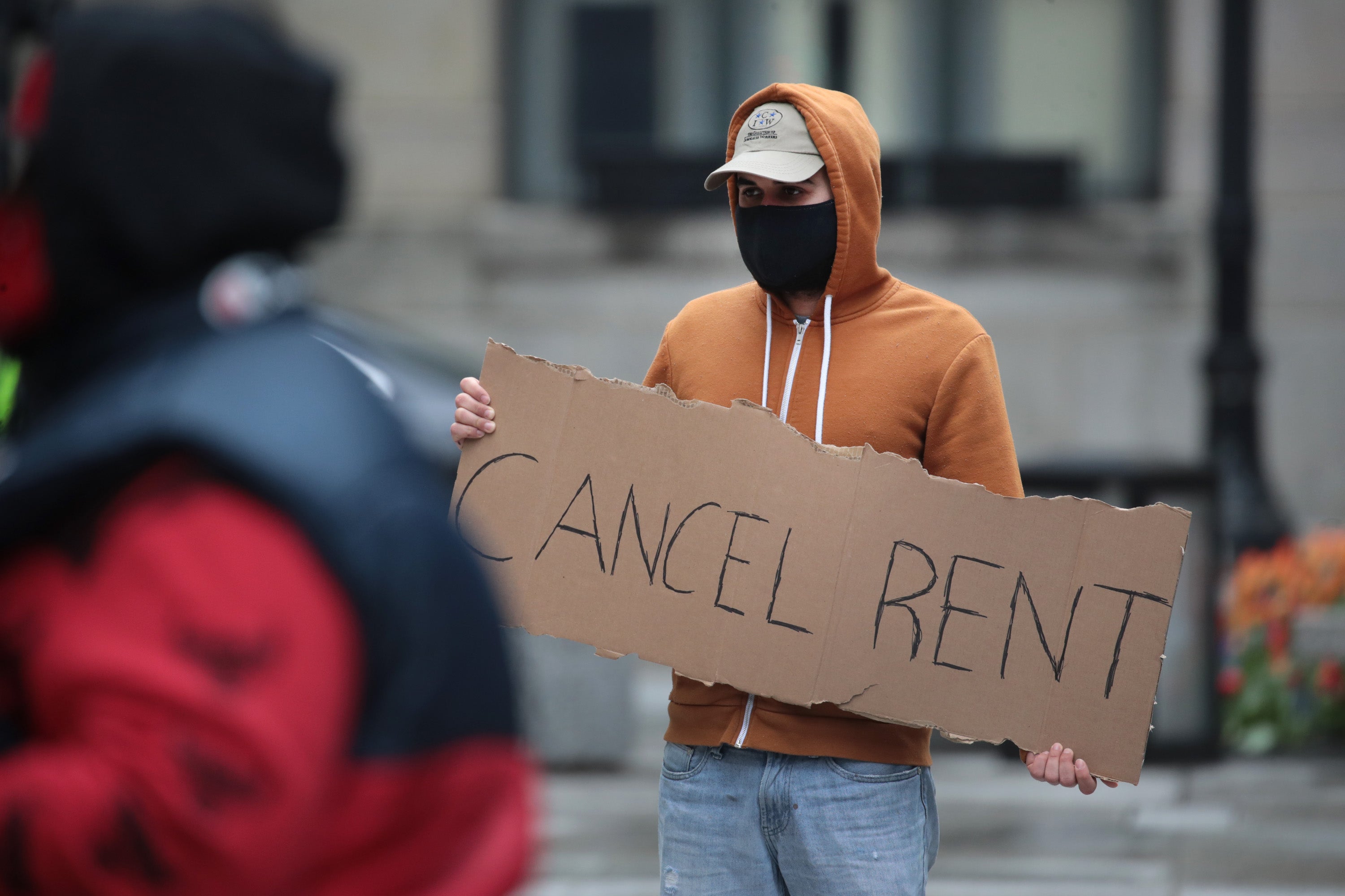 A protester in Chicago in April 2020 calling on the governor to suspend rent and mortgage payments during coronavirus.