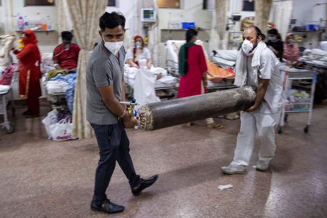 <p>Relatives of a Covid-19 patient carry an oxygen cylinder in the emergency room of a hospital in Delhi on 1 May, 2021. </p>