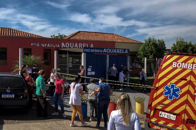 <p>Photo released by Brazilian newspaper Imprensa do Povo showing people and local authorities at the surroundings of the Aquarela Daycare School</p>