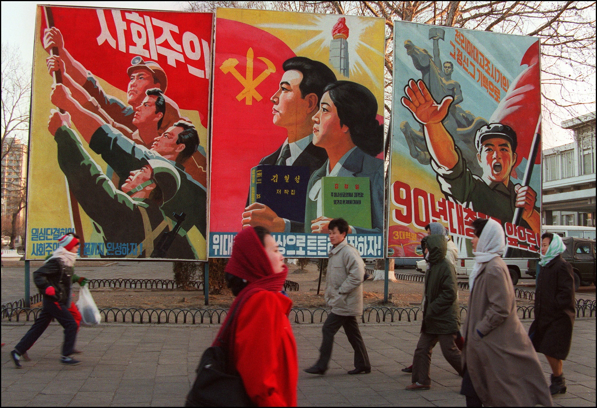 Pedestrians walk past giant propaganda boards in central Pyongyang, 1995