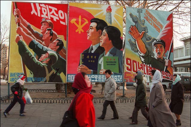 <p>Pedestrians walk past giant propaganda boards in central Pyongyang, 1995</p>