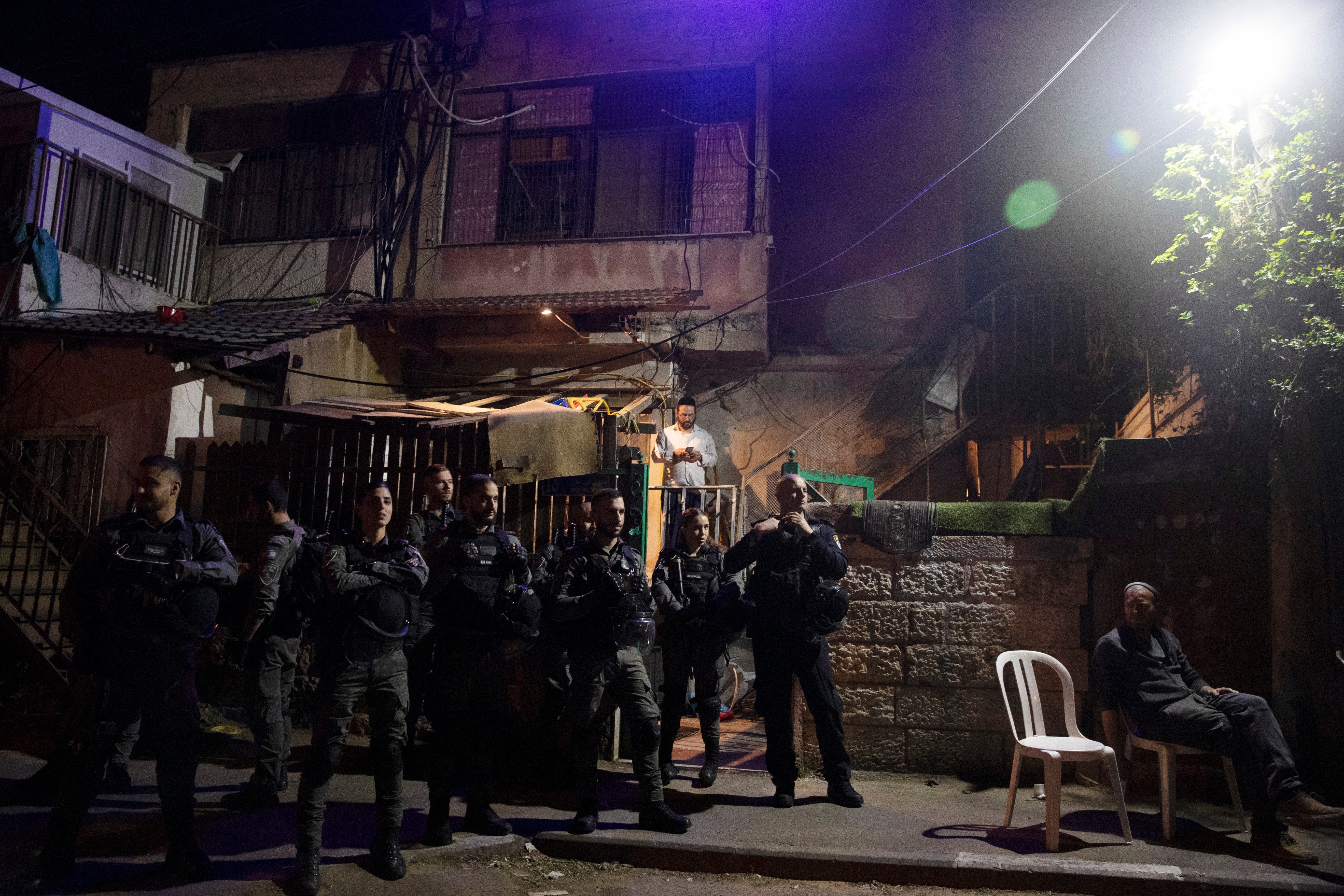 Israeli police stand guard in front of a Palestinian home in the Sheikh Jarrah neighbourhood
