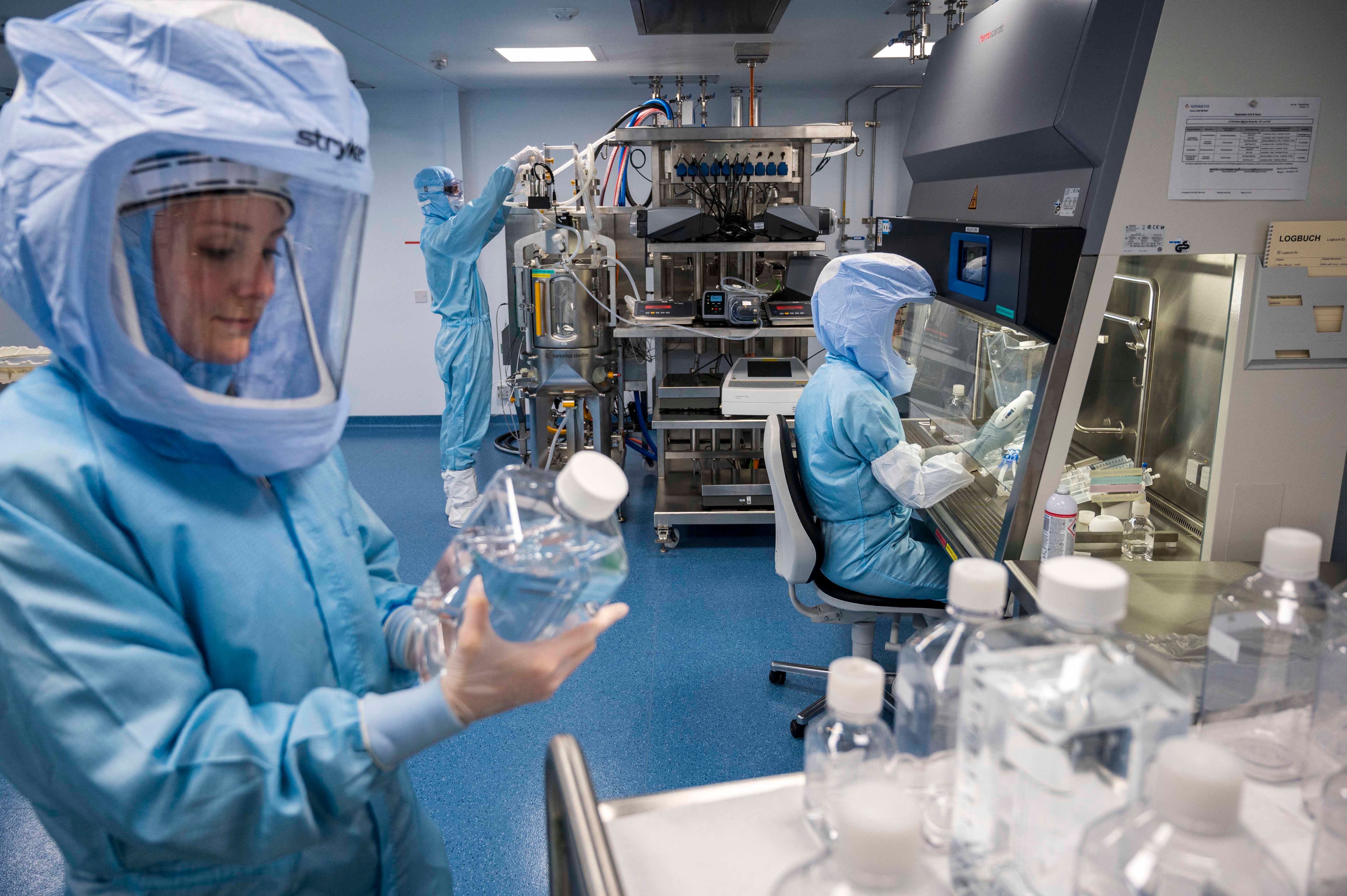 Employees checking procedures for making the Pfizer vaccine at German company BioNTech, which is being sold on a standard for-profit basis