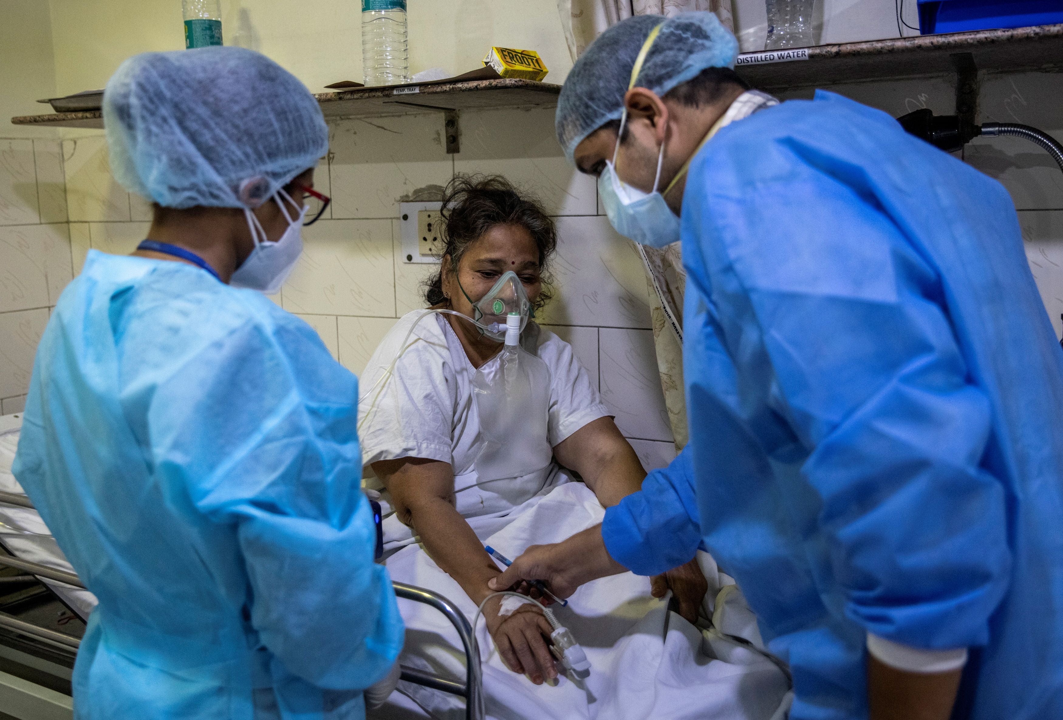 Rohan Aggarwal, 26, a resident doctor treating patients suffering from the coronavirus disease (COVID-19), tends to a patient inside the emergency room of Holy Family Hospital, during his 27-hour shift in New Delhi, India, May 1, 2021. Aggarwal says he fears what will happen if he gets infected, too, knowing that his own hospital will be unlikely to find him a bed. He is unvaccinated: He was sick in January when shots for medical professionals were being rolled out, and then by February, he began to relax. “We were all under the misconception the virus had gone,” he said. REUTERS/Danish Siddiqui