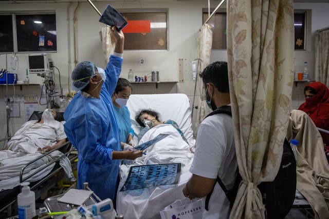 <p>Rohan Aggarwal, 26, a resident doctor treating patients suffering from the coronavirus disease (COVID-19), looks at a patient’s x-ray scan, inside the emergency room of Holy Family Hospital, during his 27-hour shift in New Delhi, India, May 1, 2021. </p>
