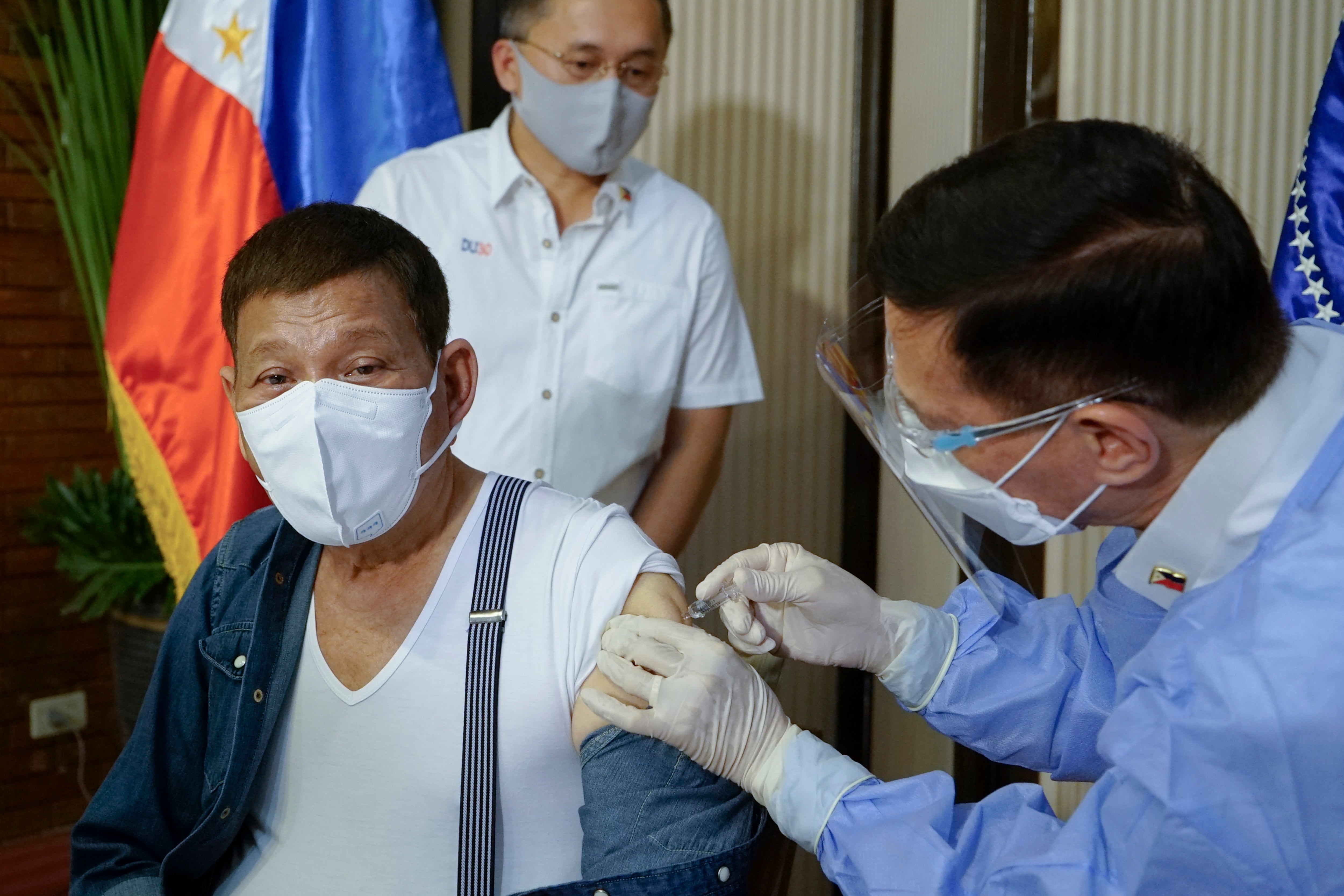 In this photo provided by the Malacanang Presidential Photographers Division, Philippine President Rodrigo Duterte, left, is inoculated with China's Sinopharm Covid-19 vaccine by Health Secretary Fracisco Duque III at the Malacanang presidential palace in Manila, Philippines on3 May, 2021