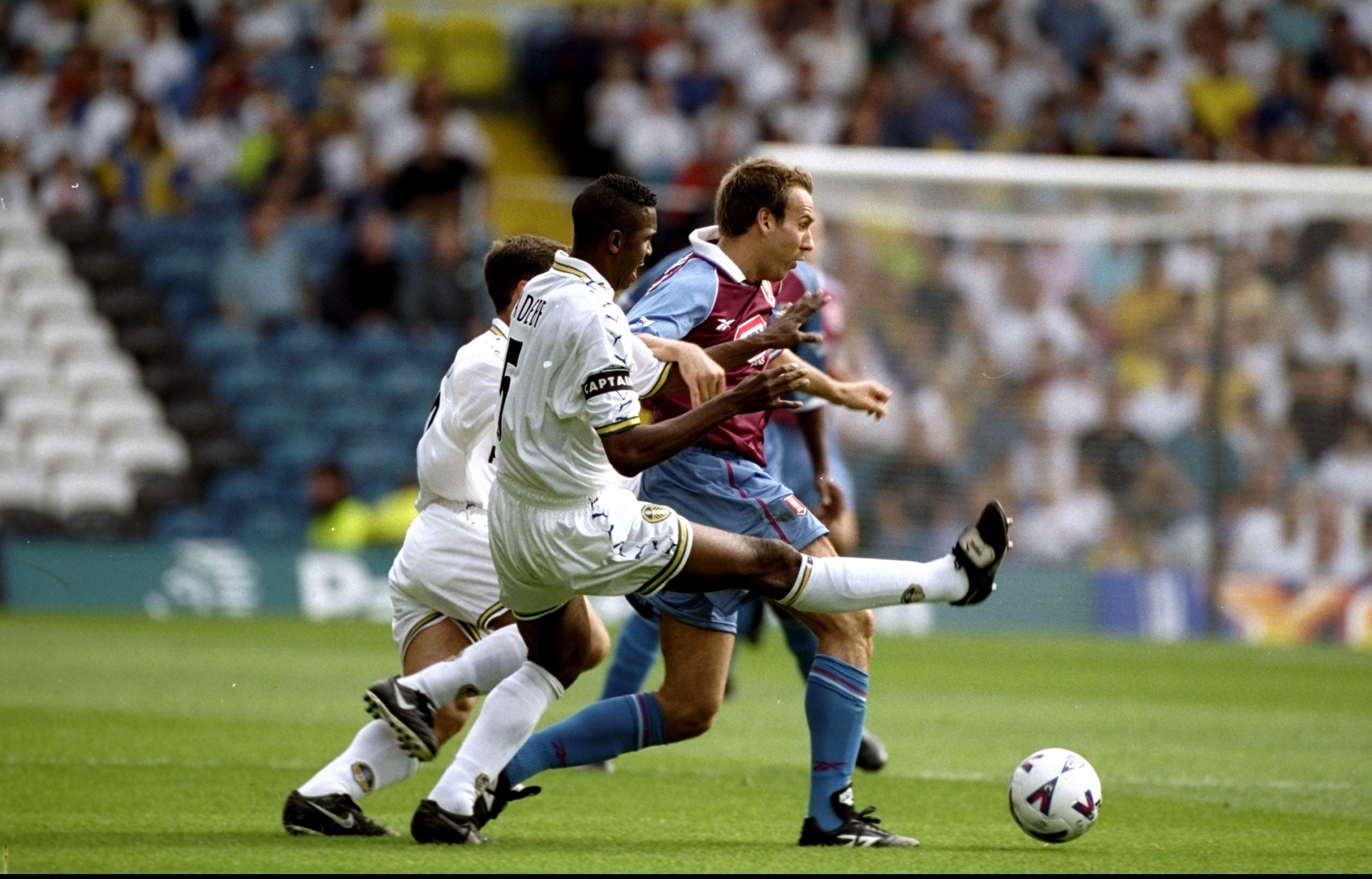 Radebe challenges Paul Merson during a match between Leeds and Aston Villa
