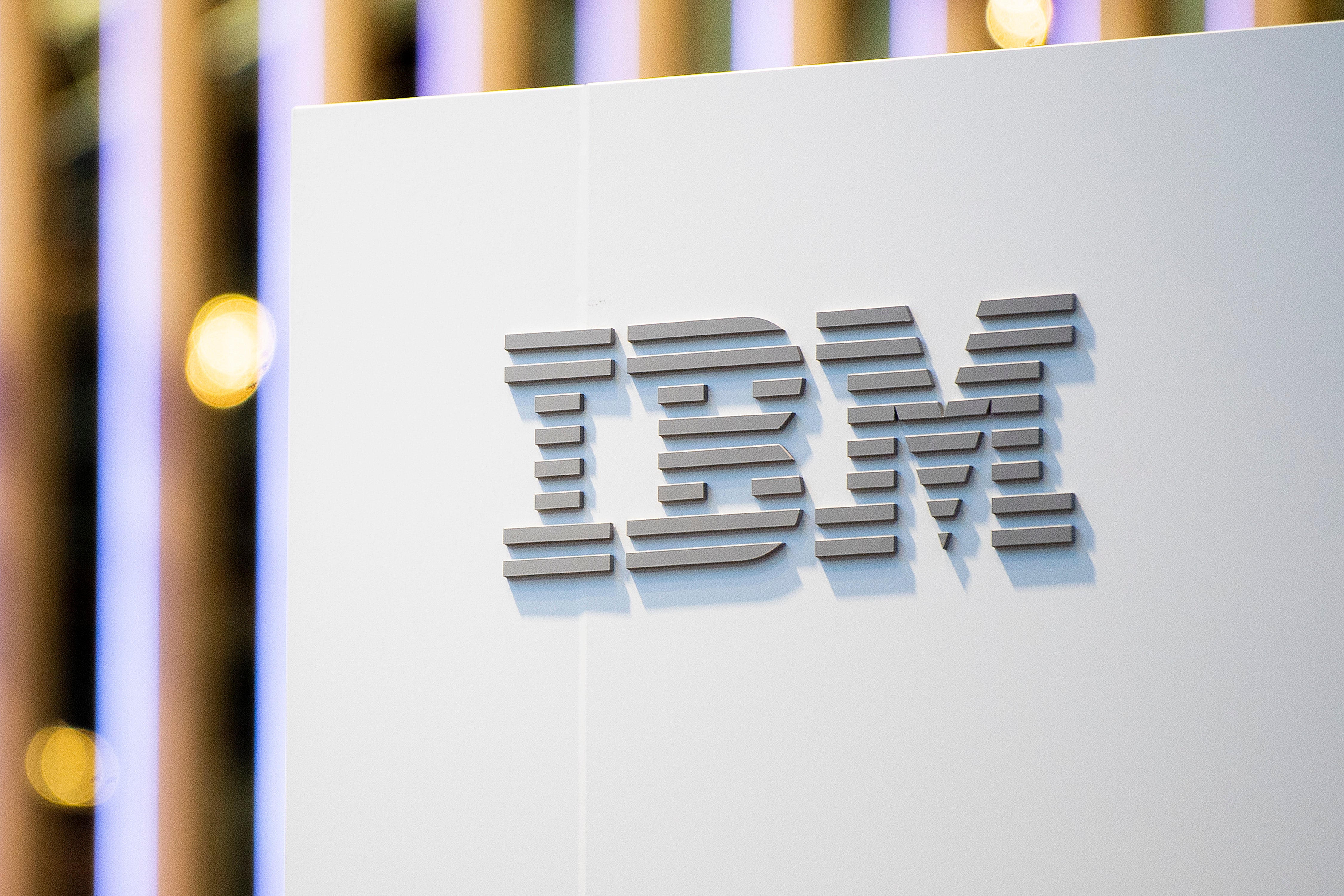 A logo sits illumintated outside the IBM booth on day 2 of the GSMA Mobile World Congress 2019