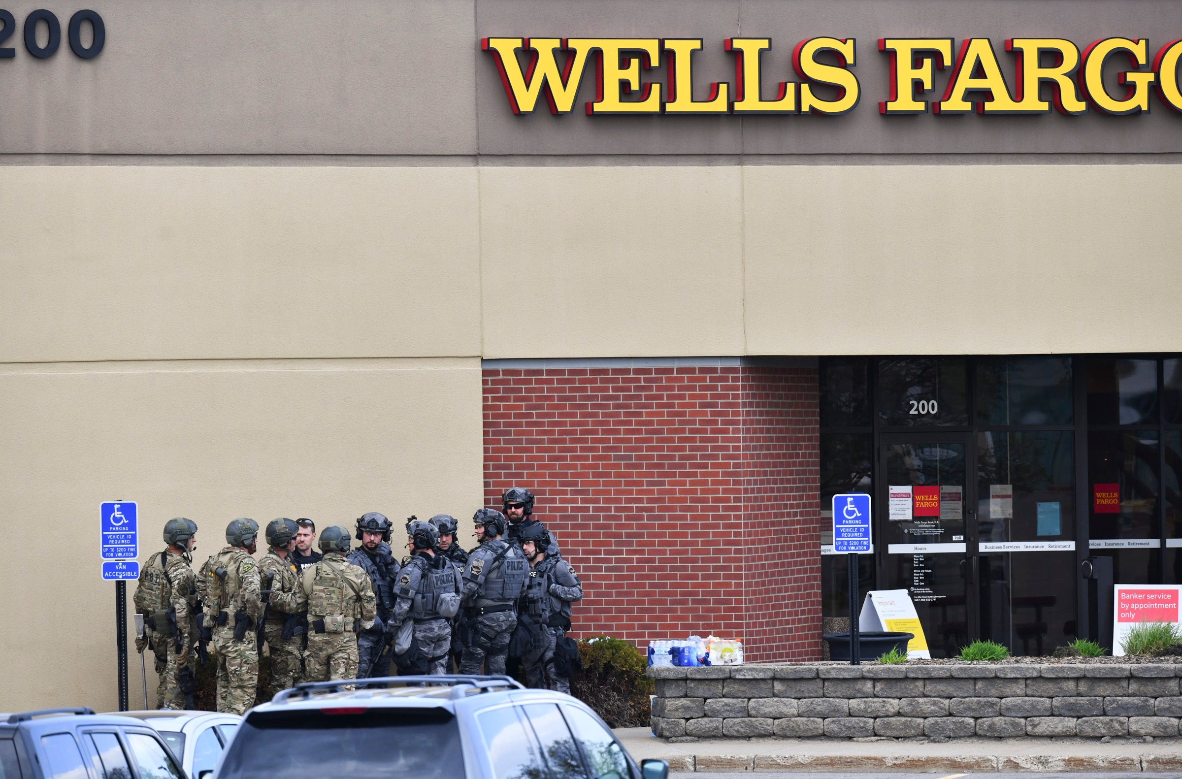 <p>Law enforcement officers gather near the entrance of a Wells Fargo Bank branch Thursday, 6 May 2021, in St Cloud, Minnesota</p>