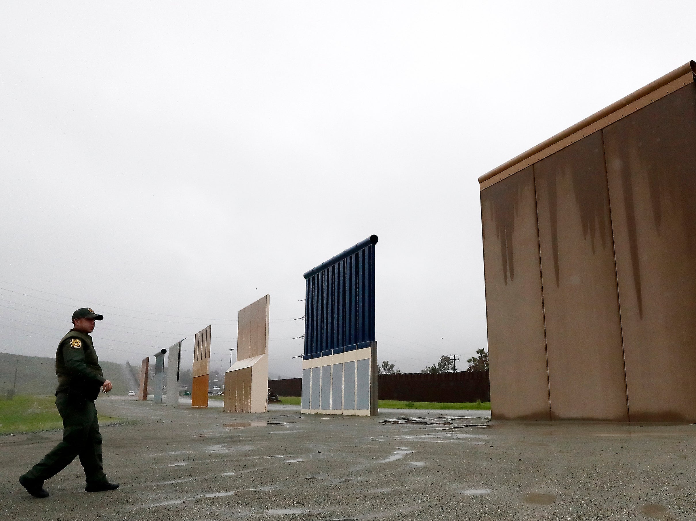 U.S. Border Patrol agent Vincent Pirro walks towards prototypes for a border wall in San Diego on Feb. 5, 2019.