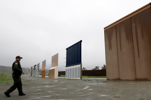 U.S. Border Patrol agent Vincent Pirro walks towards prototypes for a border wall in San Diego on Feb. 5, 2019.
