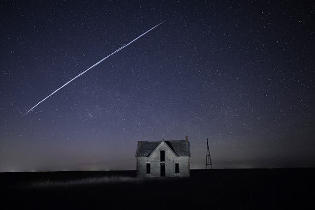 <p>A string of SpaceX Starlink satellites passes over an old stone house near Florence, Kansas,  6 May, 2021 </p>
