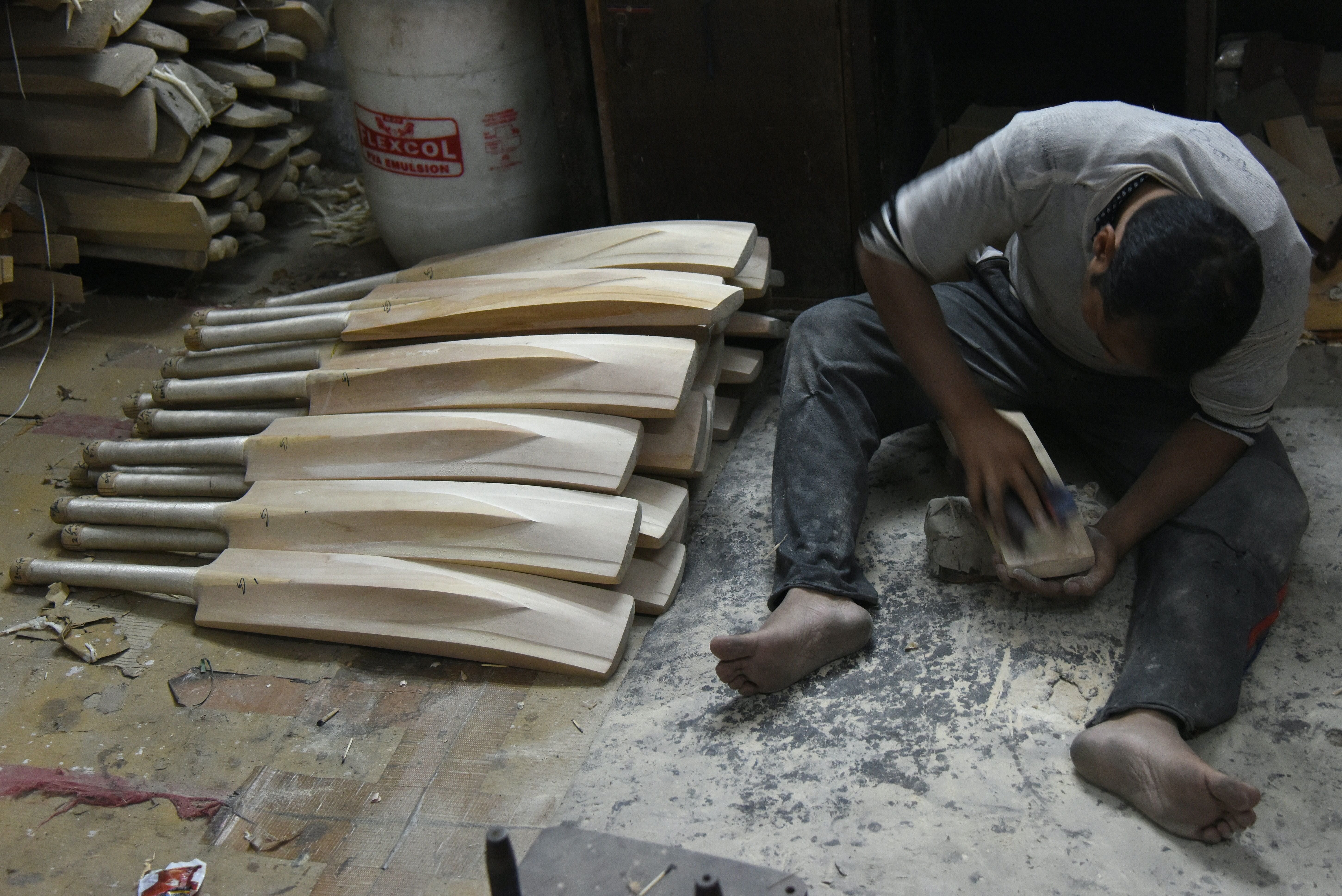 An Indian craftsman works on unfinished cricket bats in a factory in Meerut