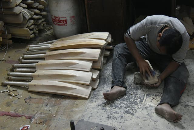 <p>An Indian craftsman works on unfinished cricket bats in a factory in Meerut</p>