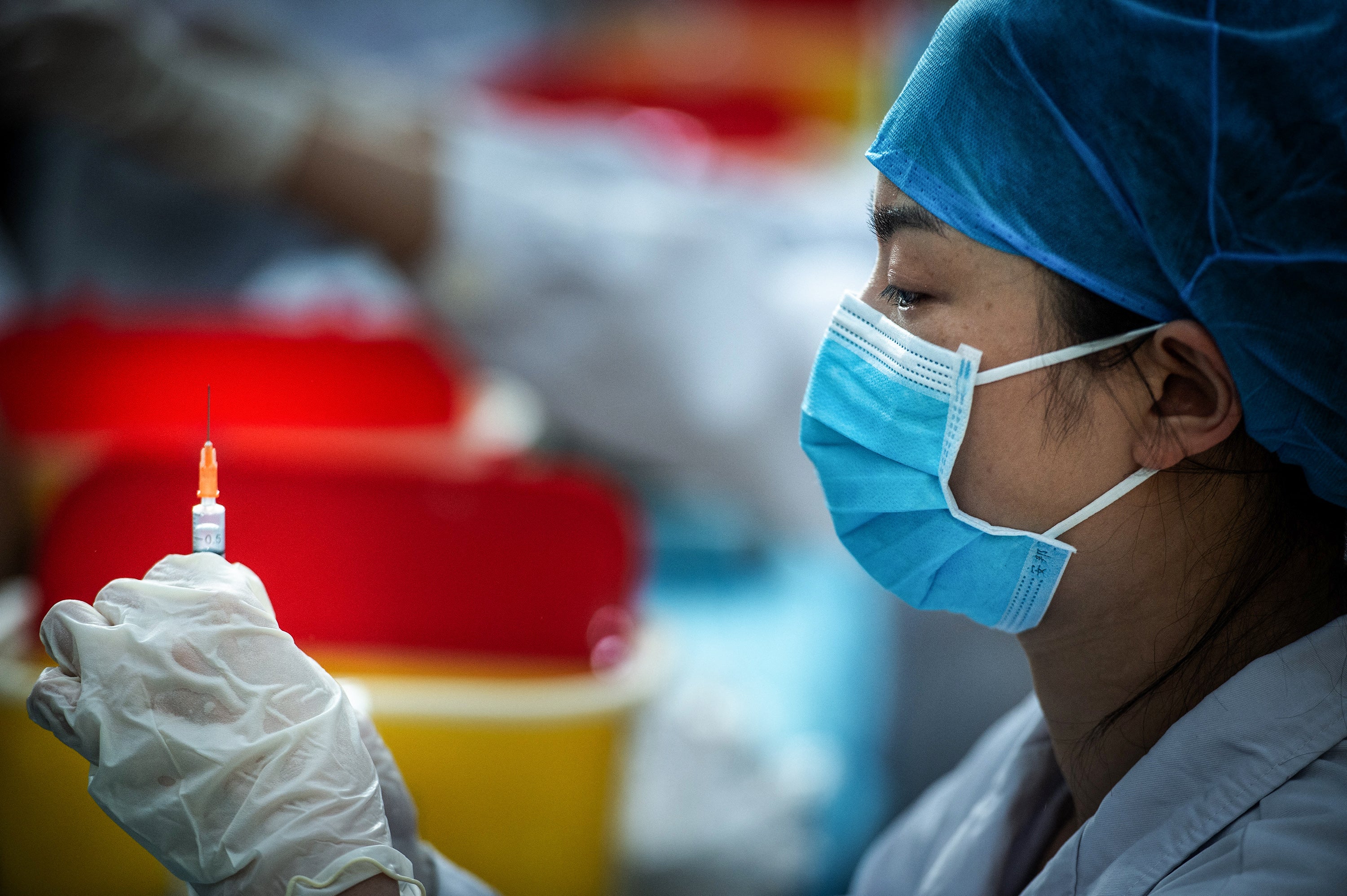 File Image: This photo taken on 28 April 2021 shows a medical staff member preparing a dose for a university student to get vaccinated against the Covid-19 coronavirus at a university in Wuhan, in China's central Hubei province