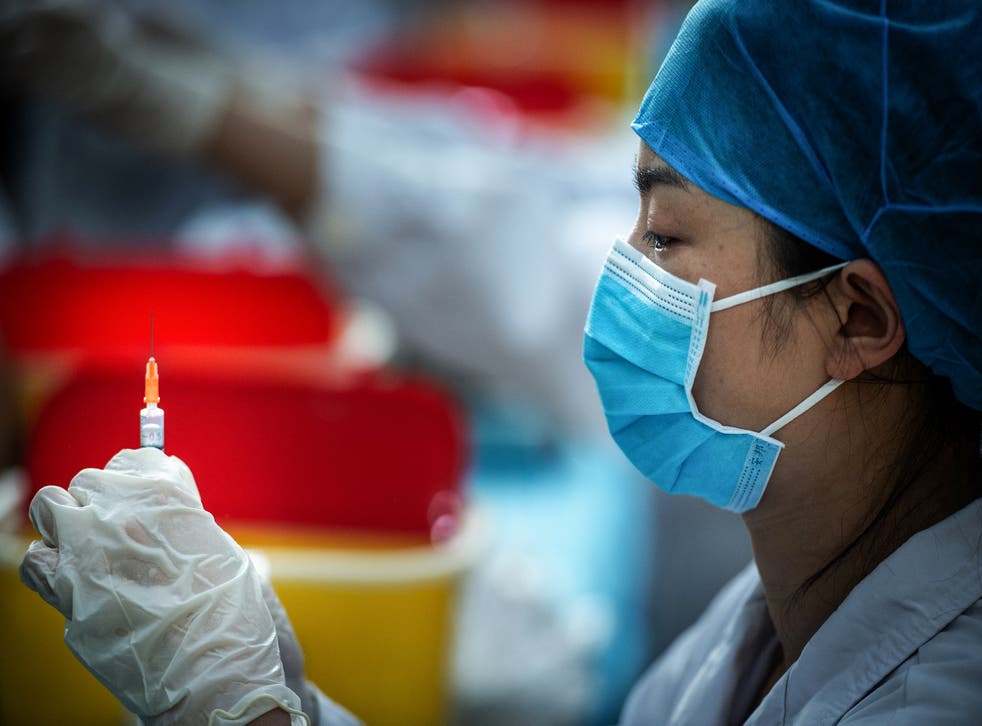 <p>File Image: This photo taken on 28 April 2021 shows a medical staff member preparing a dose for a university student to get vaccinated against the Covid-19 coronavirus at a university in Wuhan, in China's central Hubei province</p>