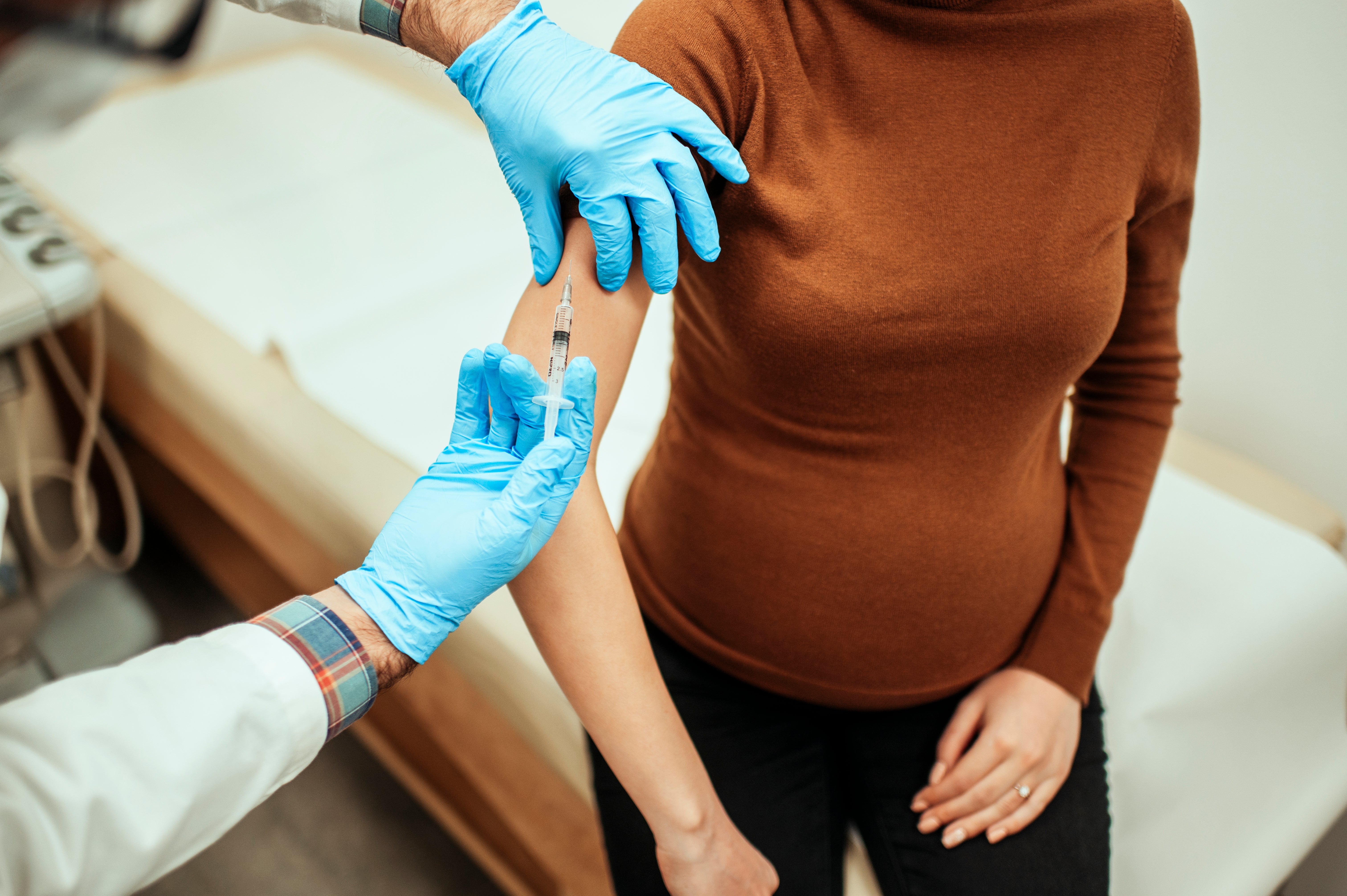 A pregnant woman getting vaccinated against flu or coronavirus