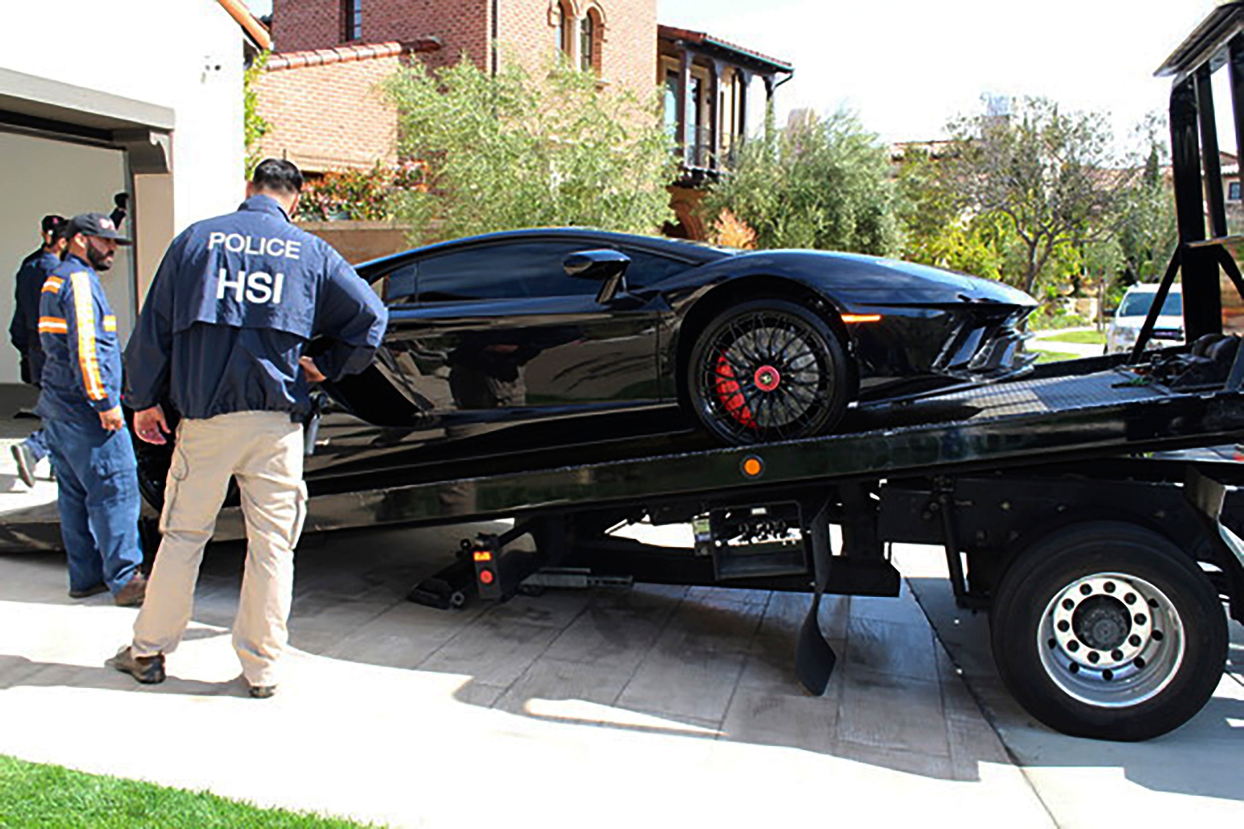 Special agents with HSI Los Angeles's El Camino Real Financial Crimes Task Force seize a Lamborghini from an Orange County businessman on Thursday, April 6, 2021, in Irvine, California